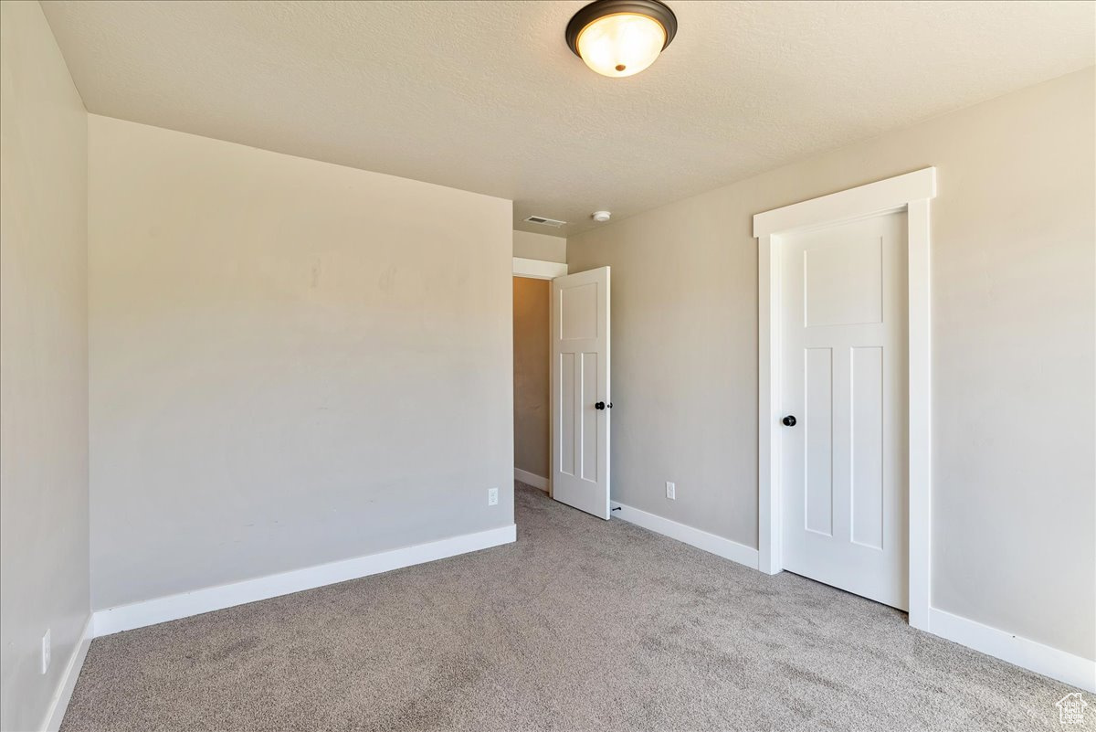 Unfurnished bedroom featuring light colored carpet