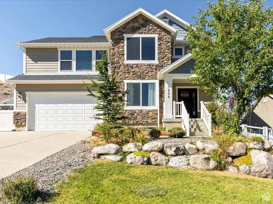 Craftsman inspired home with a garage and a front yard