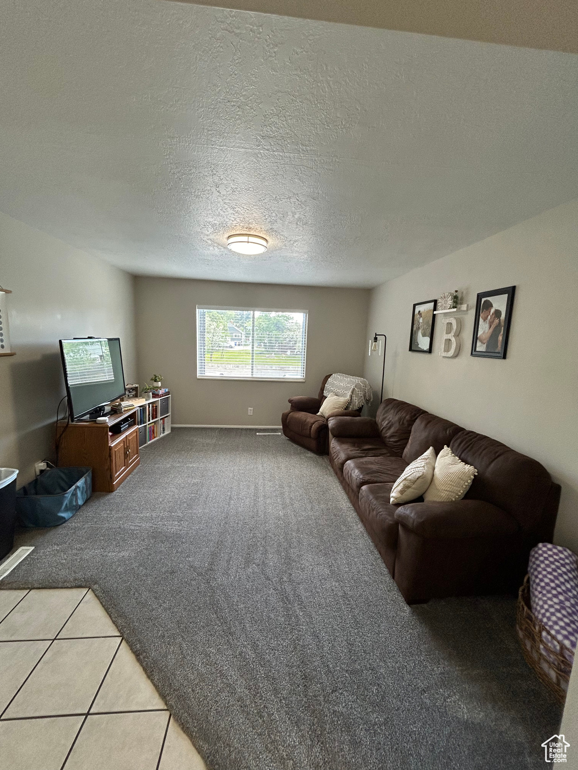 Living room with a textured ceiling and carpet