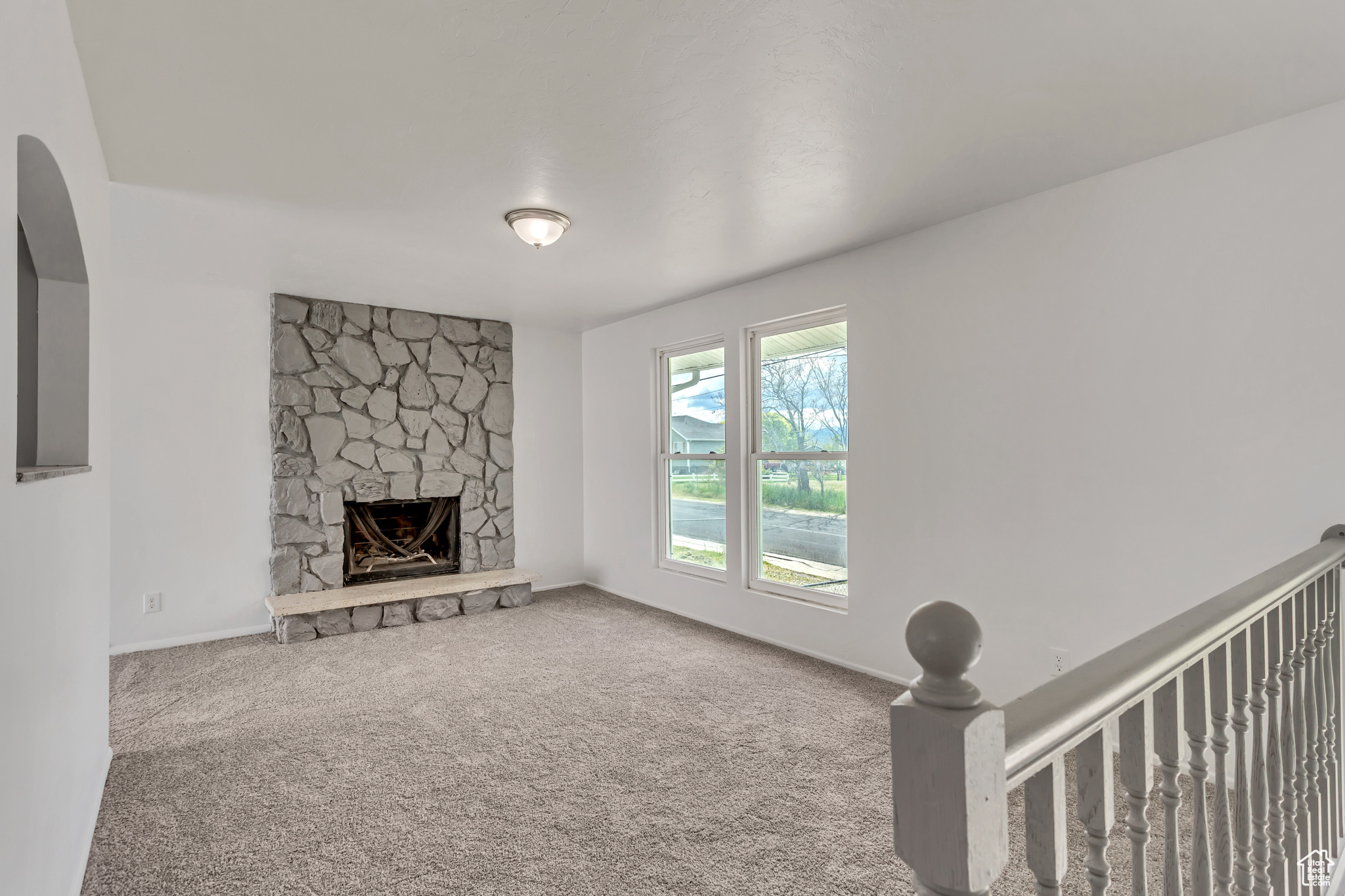 Living room with a stone fireplace and carpet floors