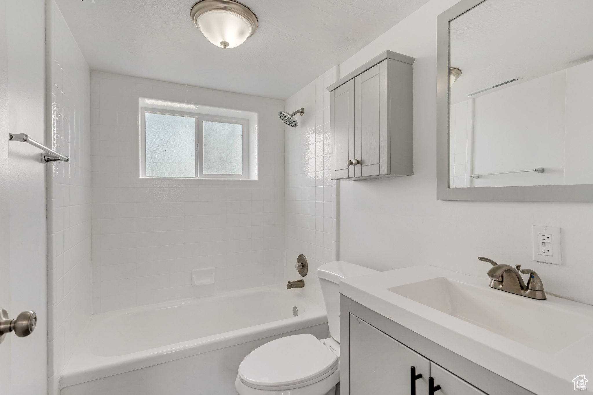 Full bathroom featuring toilet, vanity, and washtub / shower combination