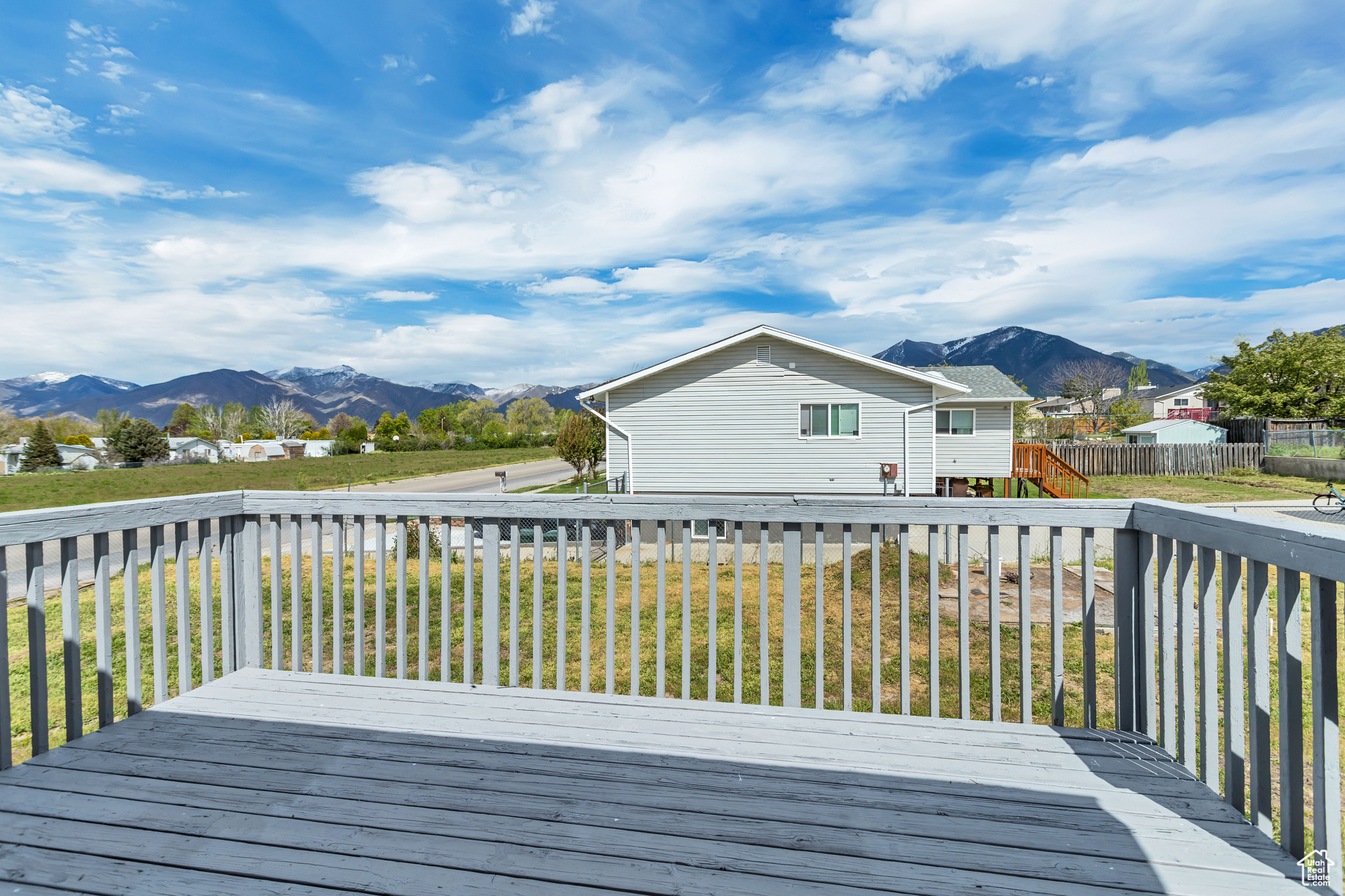 Wooden deck with a mountain view and a yard