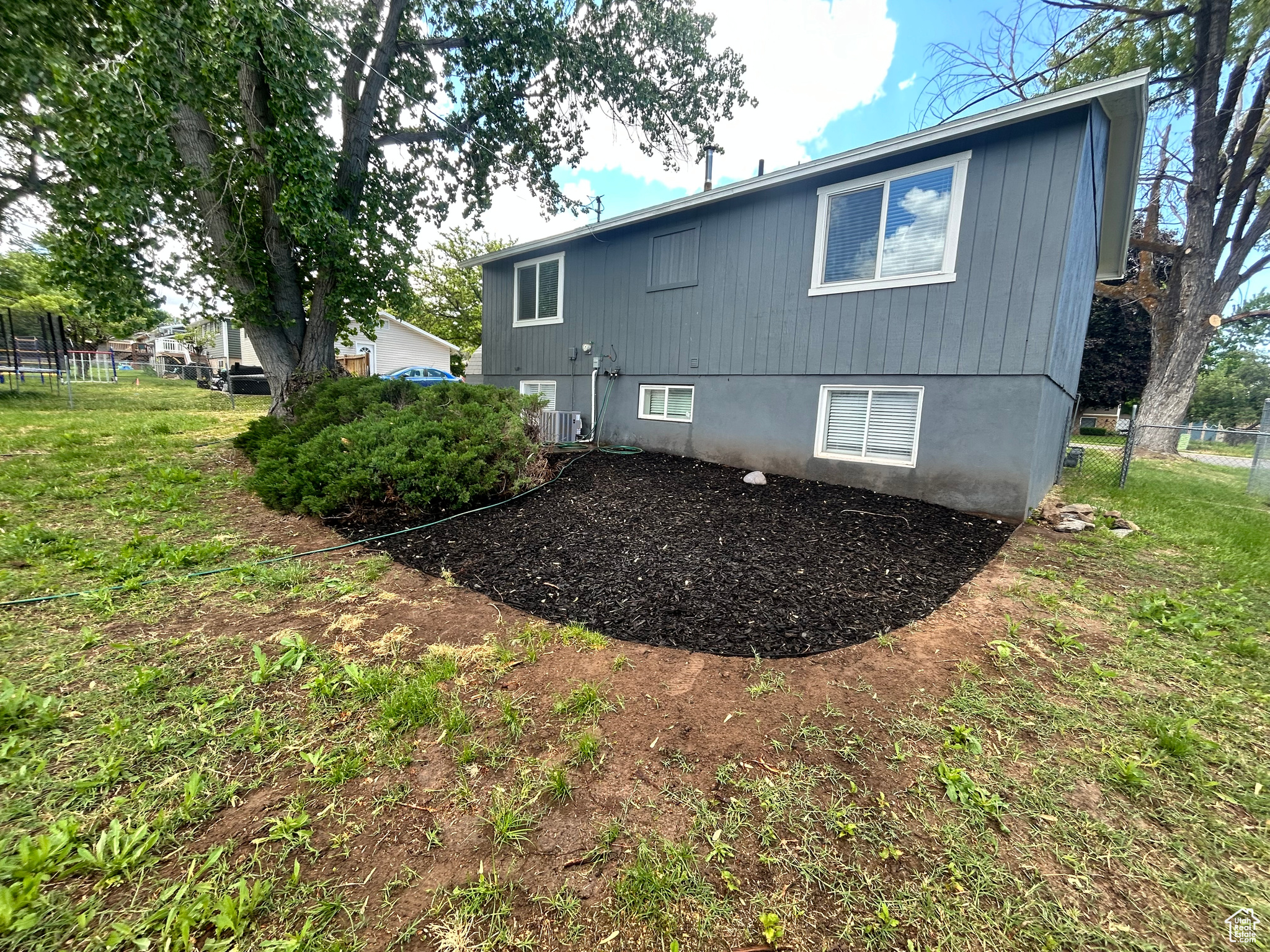 Rear view of property featuring central AC and a yard