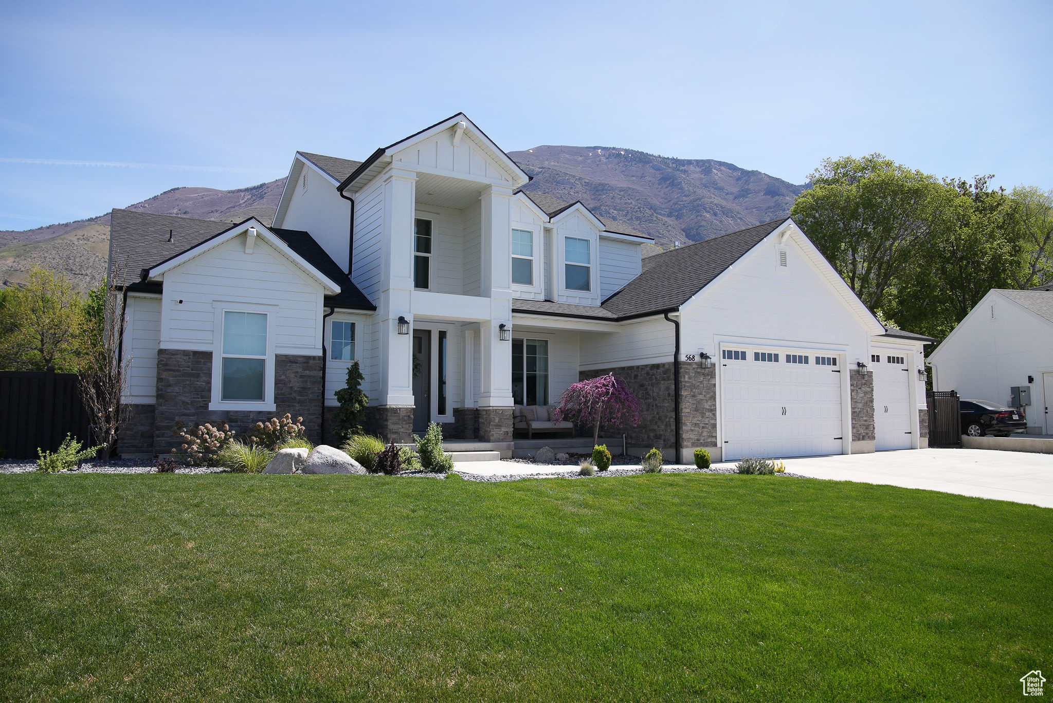 View of front of home with a garage, a front yard, and a mountain view