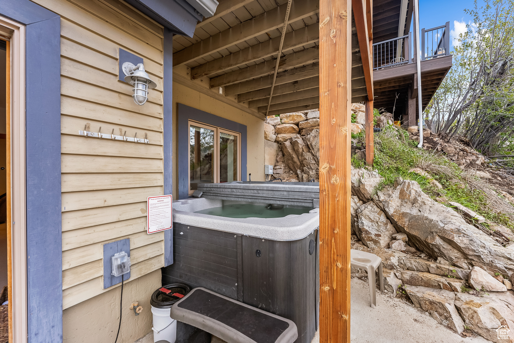 View of patio / terrace with a hot tub and a balcony