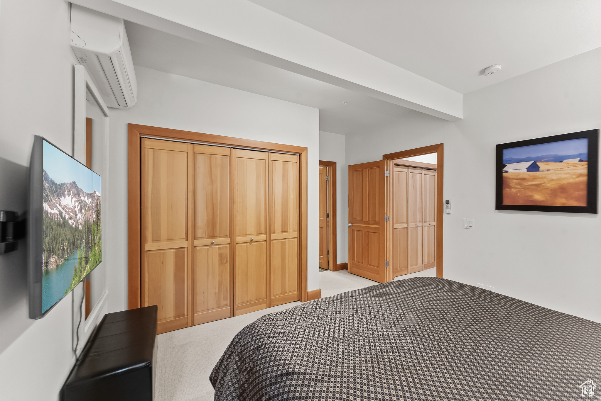 Bedroom featuring a closet, carpet floors, and a wall mounted air conditioner