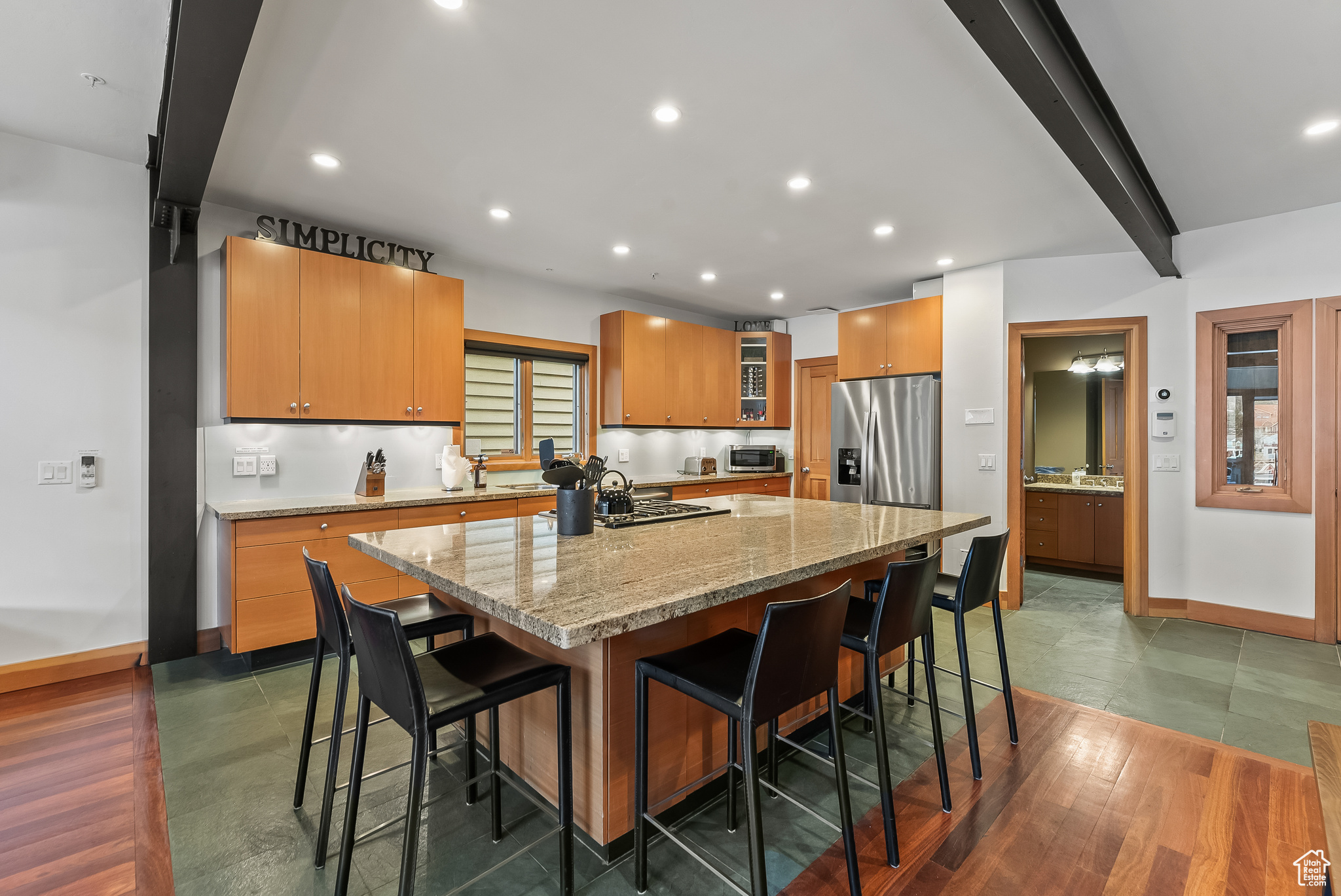 Kitchen with a center island, beam ceiling, stainless steel refrigerator with ice dispenser, and a breakfast bar