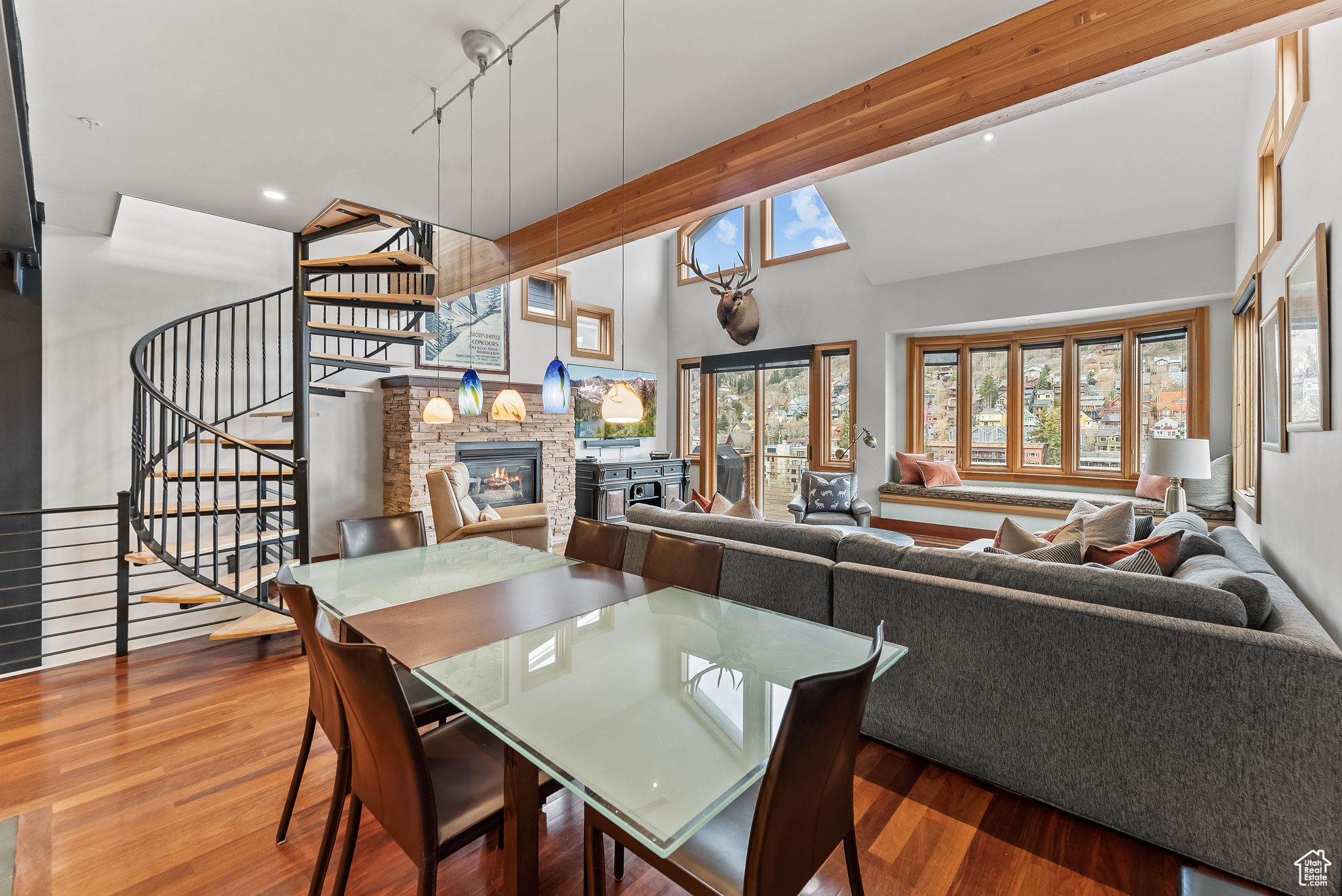 Dining area with high vaulted ceiling, a fireplace, track lighting, and hardwood / wood-style floors