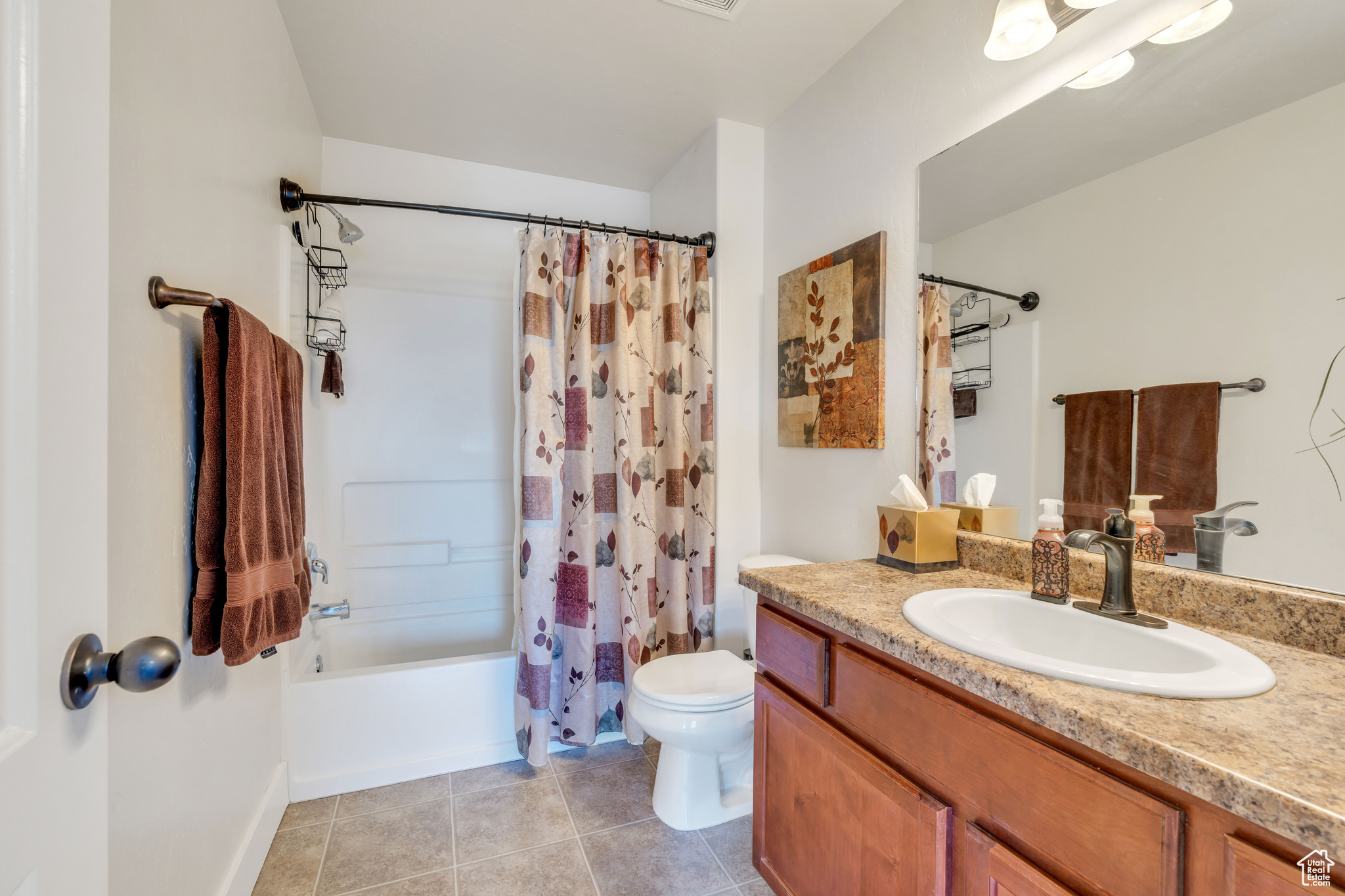 Full bathroom with shower / bathtub combination with curtain, tile flooring, vanity, and toilet