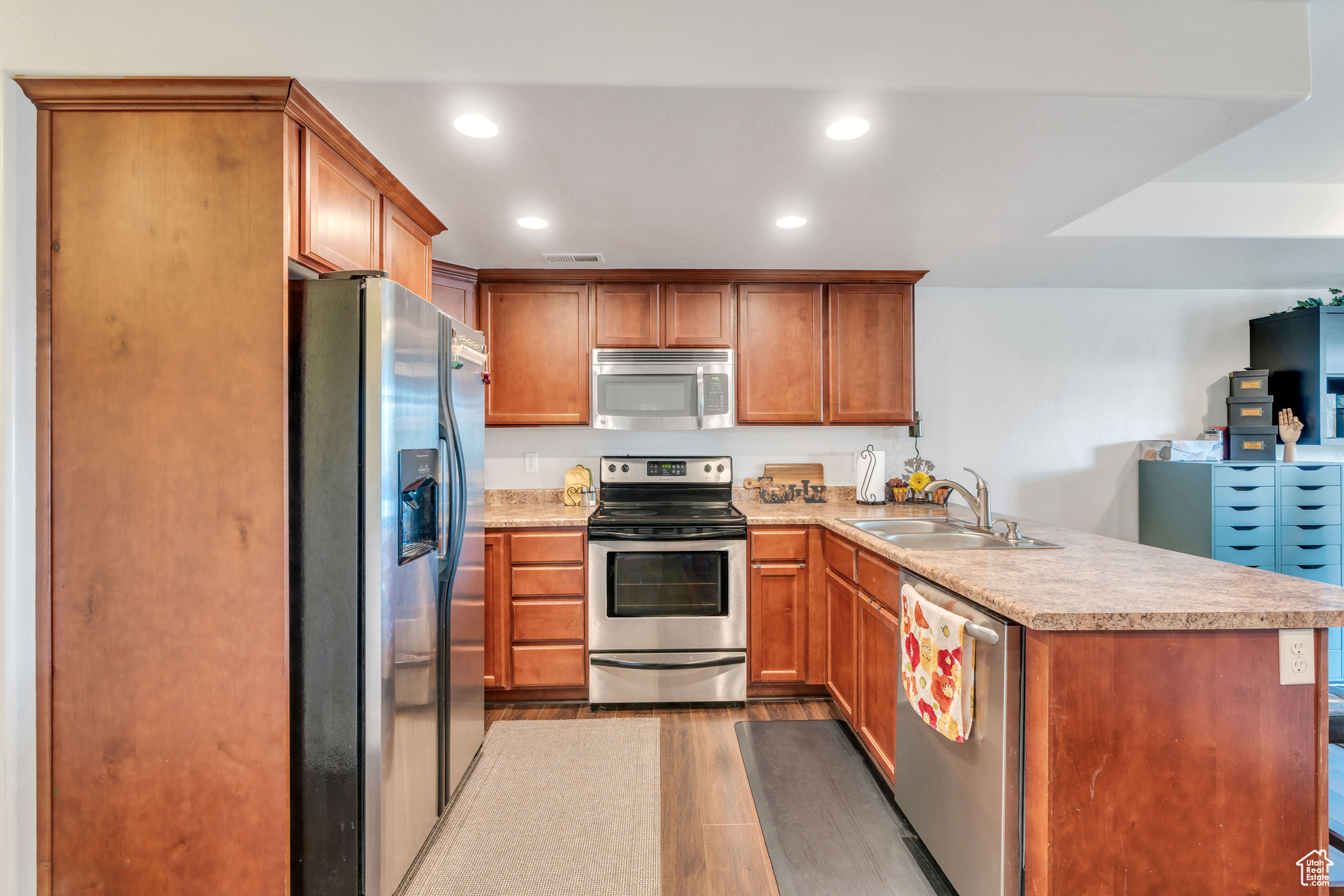 Kitchen featuring appliances with stainless steel finishes, sink, hardwood / wood-style floors, and kitchen peninsula
