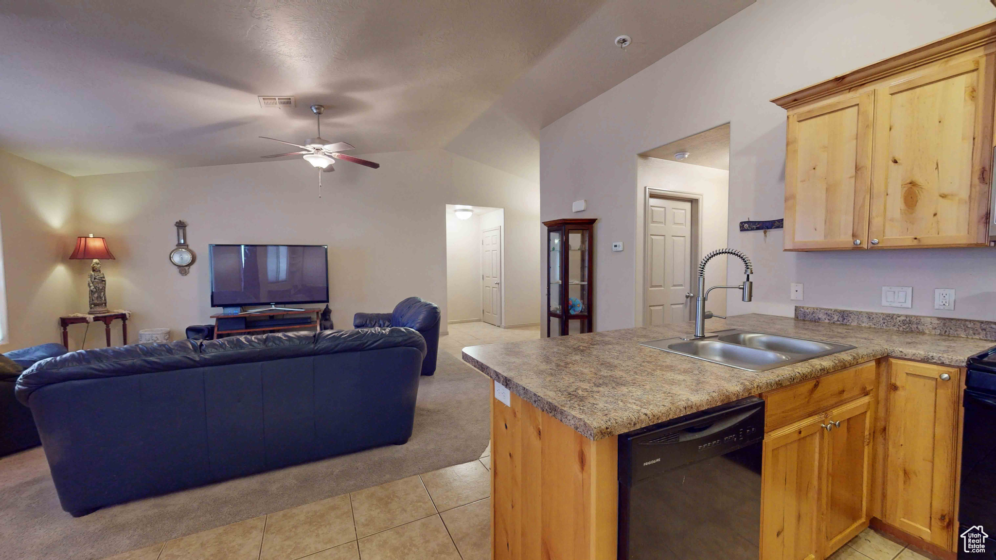 Kitchen featuring black appliances, vaulted ceiling, sink, ceiling fan, and light tile floors