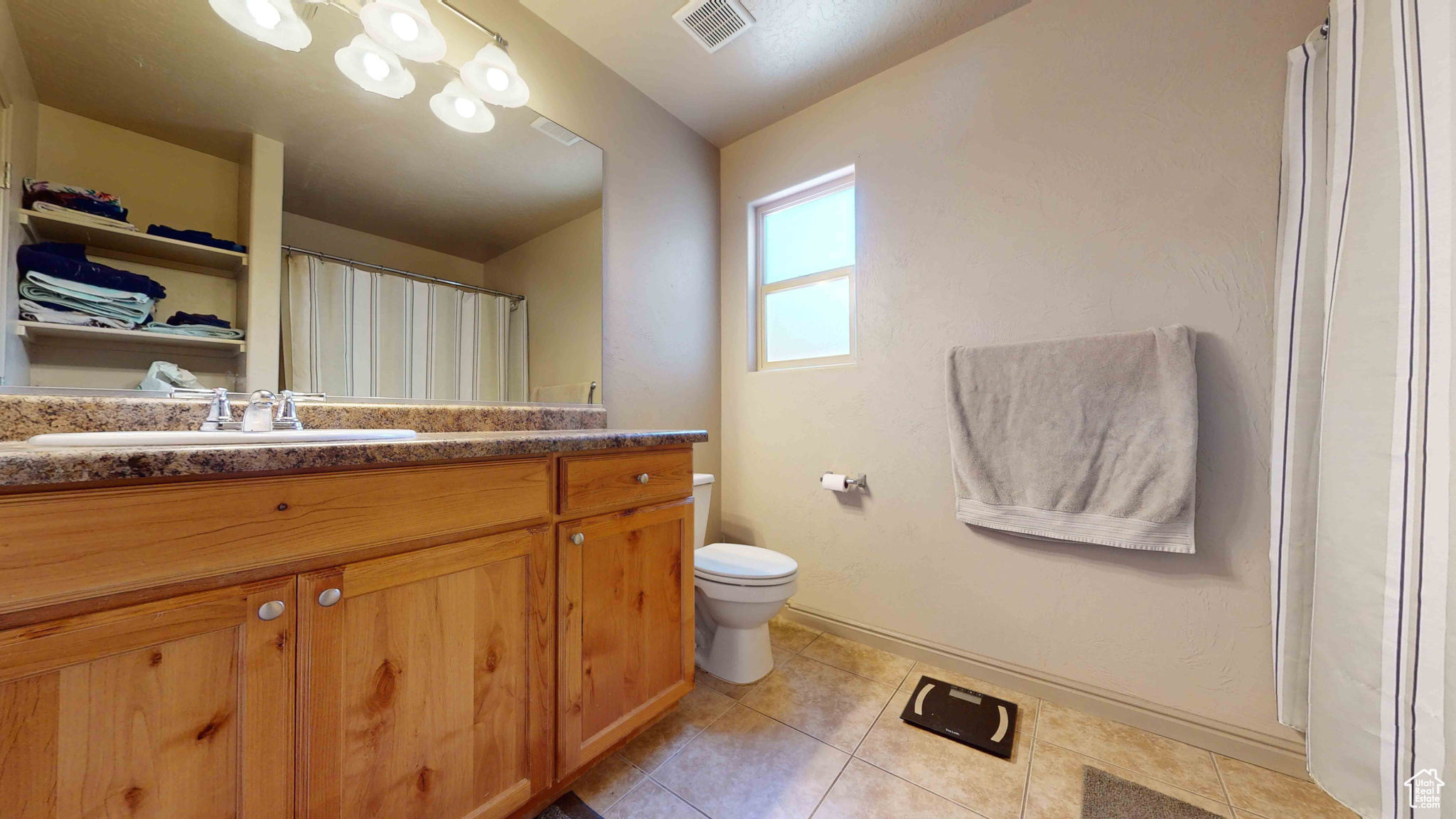 Bathroom with tile flooring, toilet, and vanity