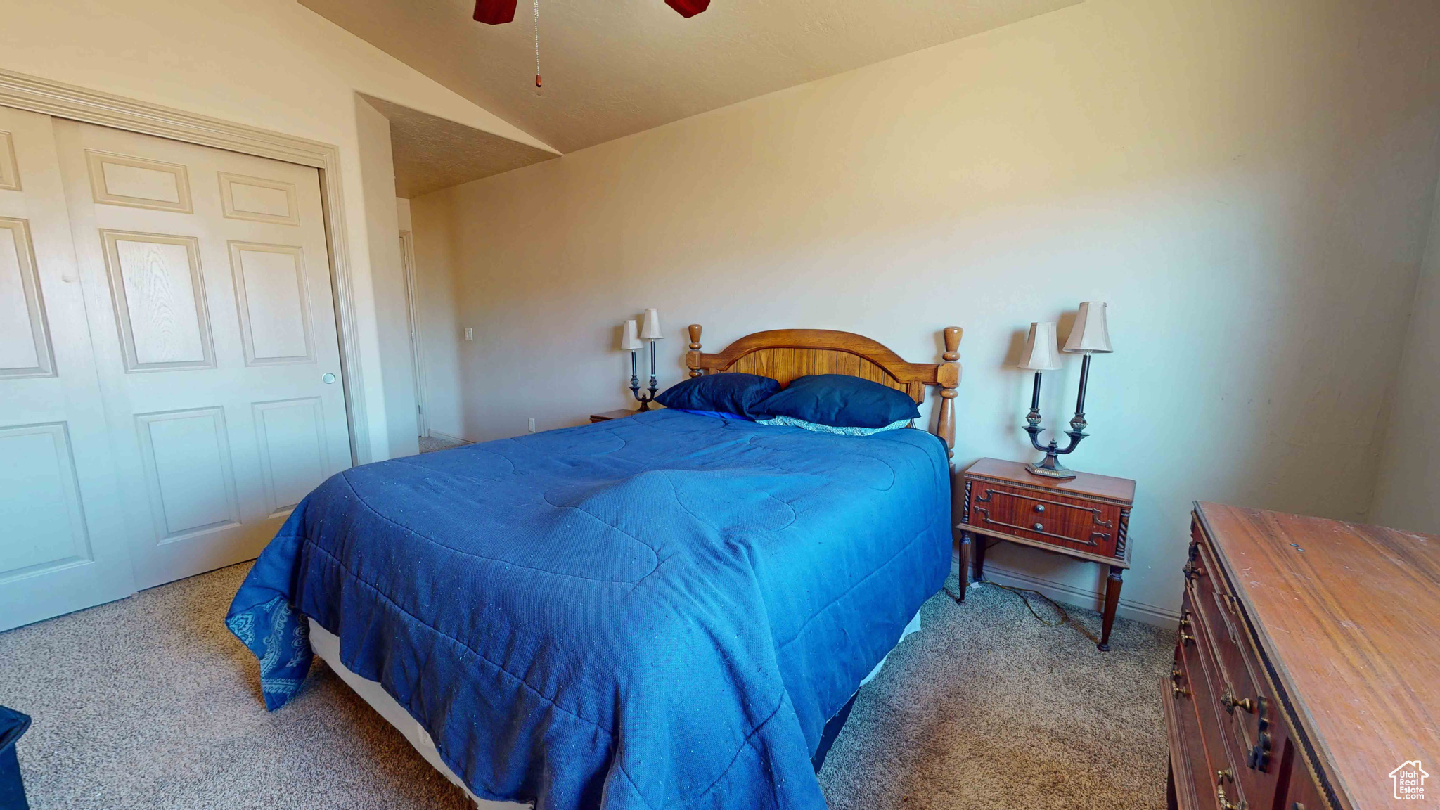 Carpeted bedroom featuring a closet, ceiling fan, and lofted ceiling