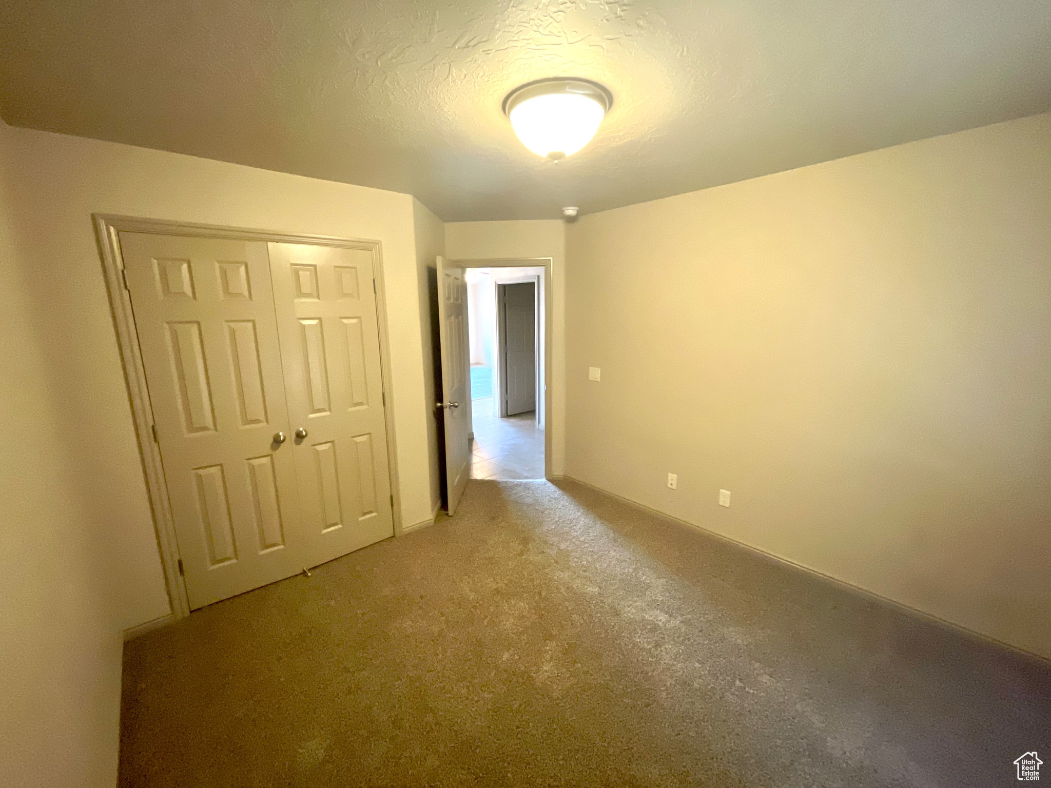 Unfurnished bedroom with a closet and light colored carpet