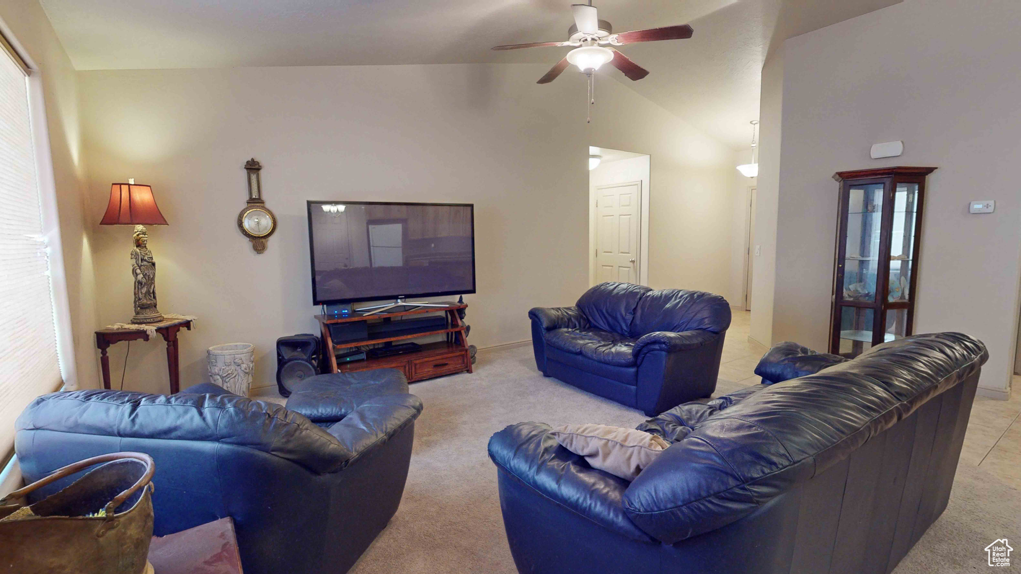 Living room with plenty of natural light, lofted ceiling, carpet, and ceiling fan