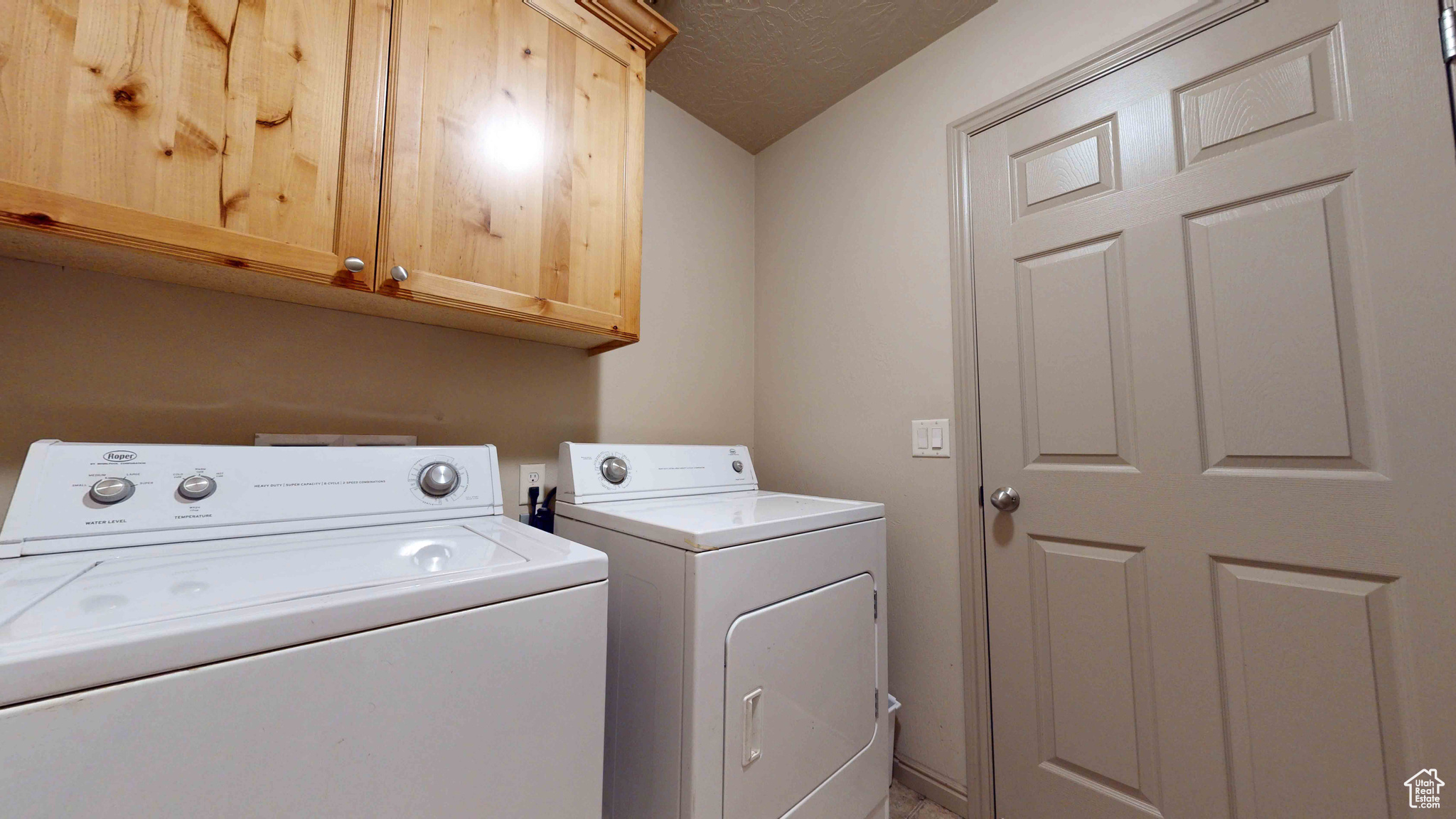 Laundry room with washer and clothes dryer and cabinets