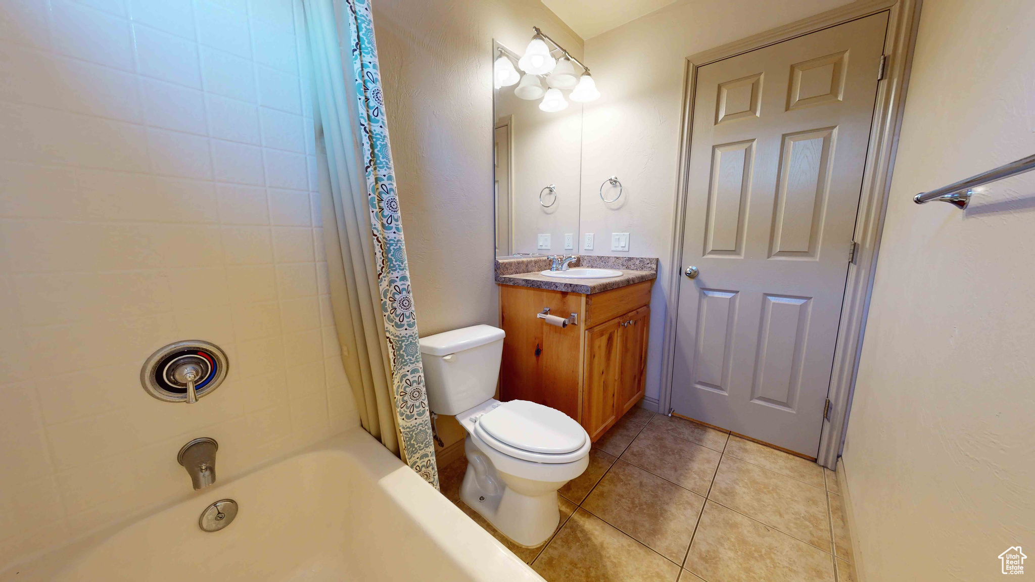 Full bathroom with shower / bathtub combination with curtain, tile flooring, toilet, and vanity