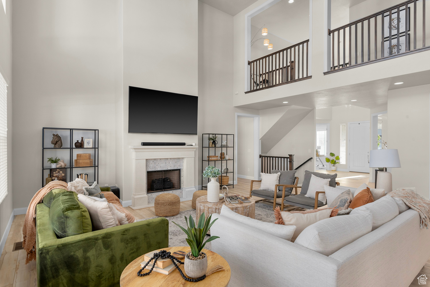 Living room with brand new upgraded LVP wood-style floors, tile fireplace surround, wood burning fireplace, 2 story windows and a high ceiling. 80