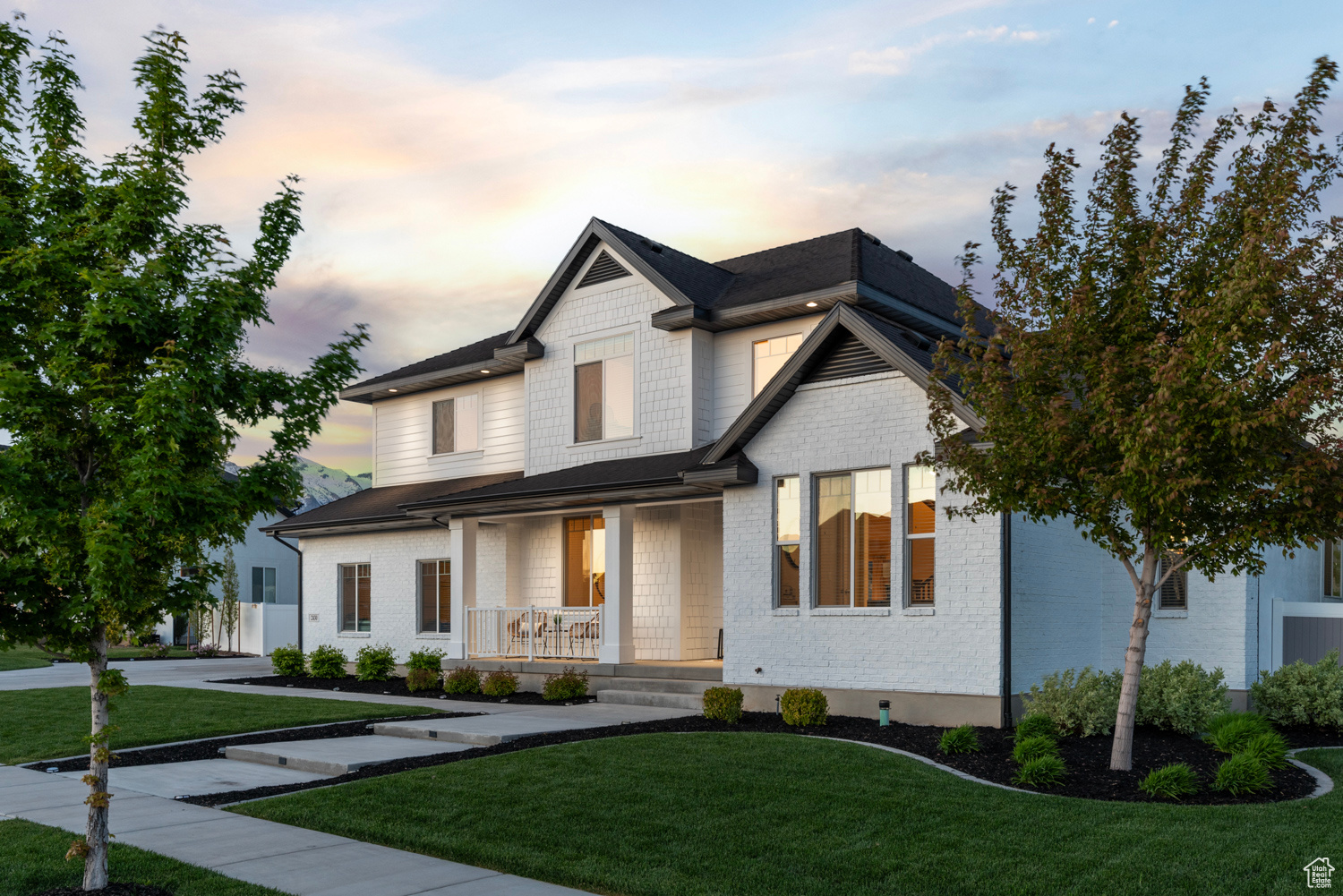 Modern farmhouse style home with spacious front porch and meticulous landscaping with fresh mulch