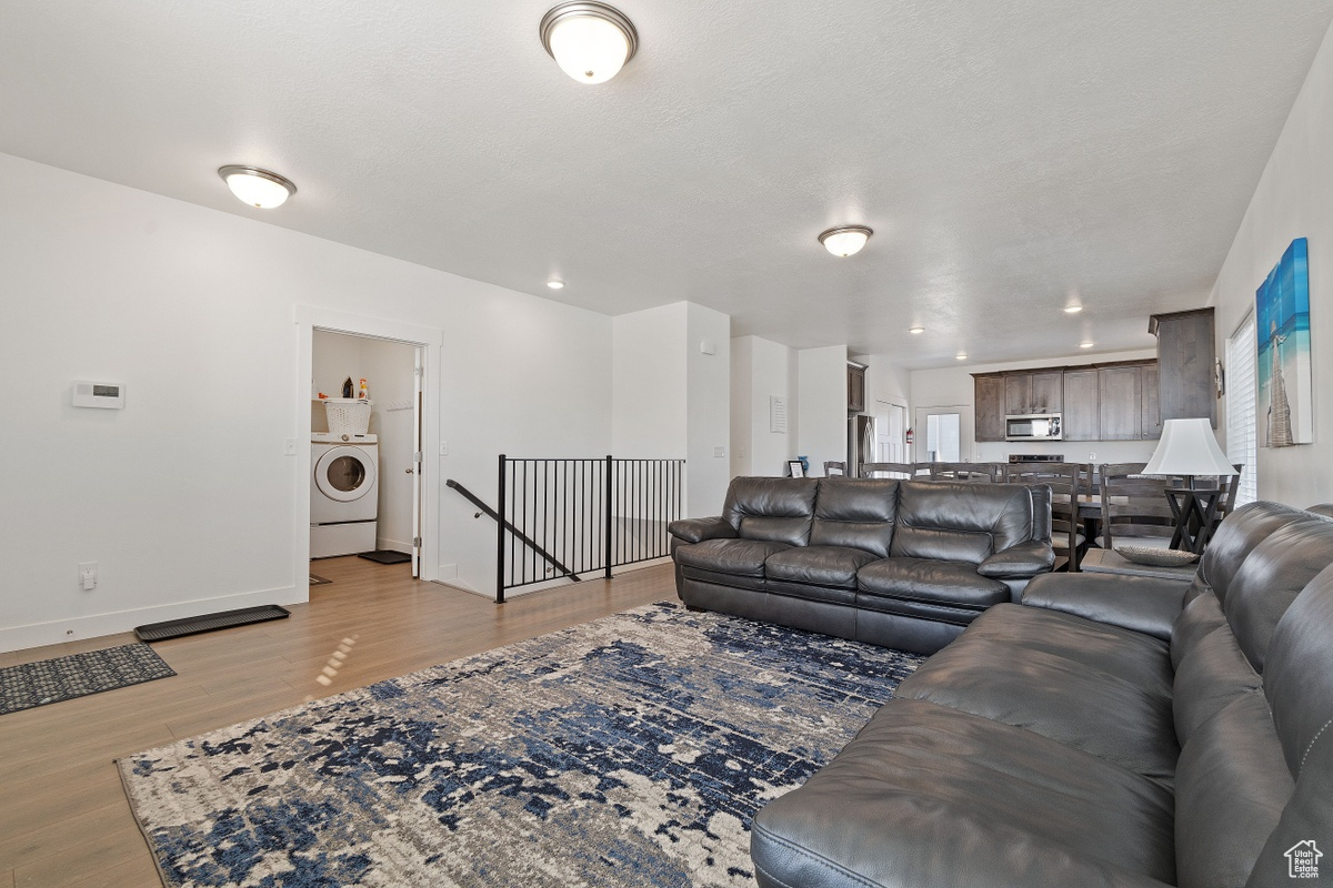 Living room with light hardwood / wood-style flooring and washer / dryer