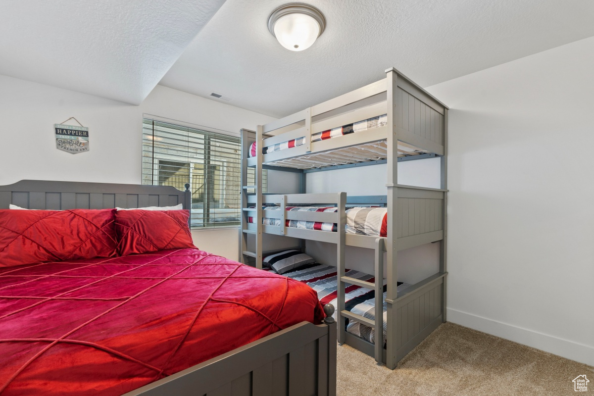 Bedroom featuring carpet floors and a textured ceiling