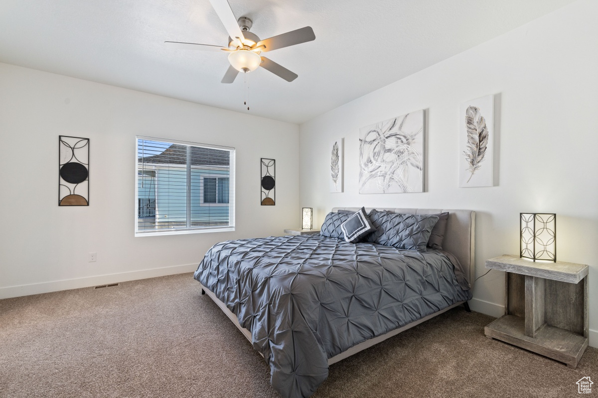 Carpeted bedroom with ceiling fan