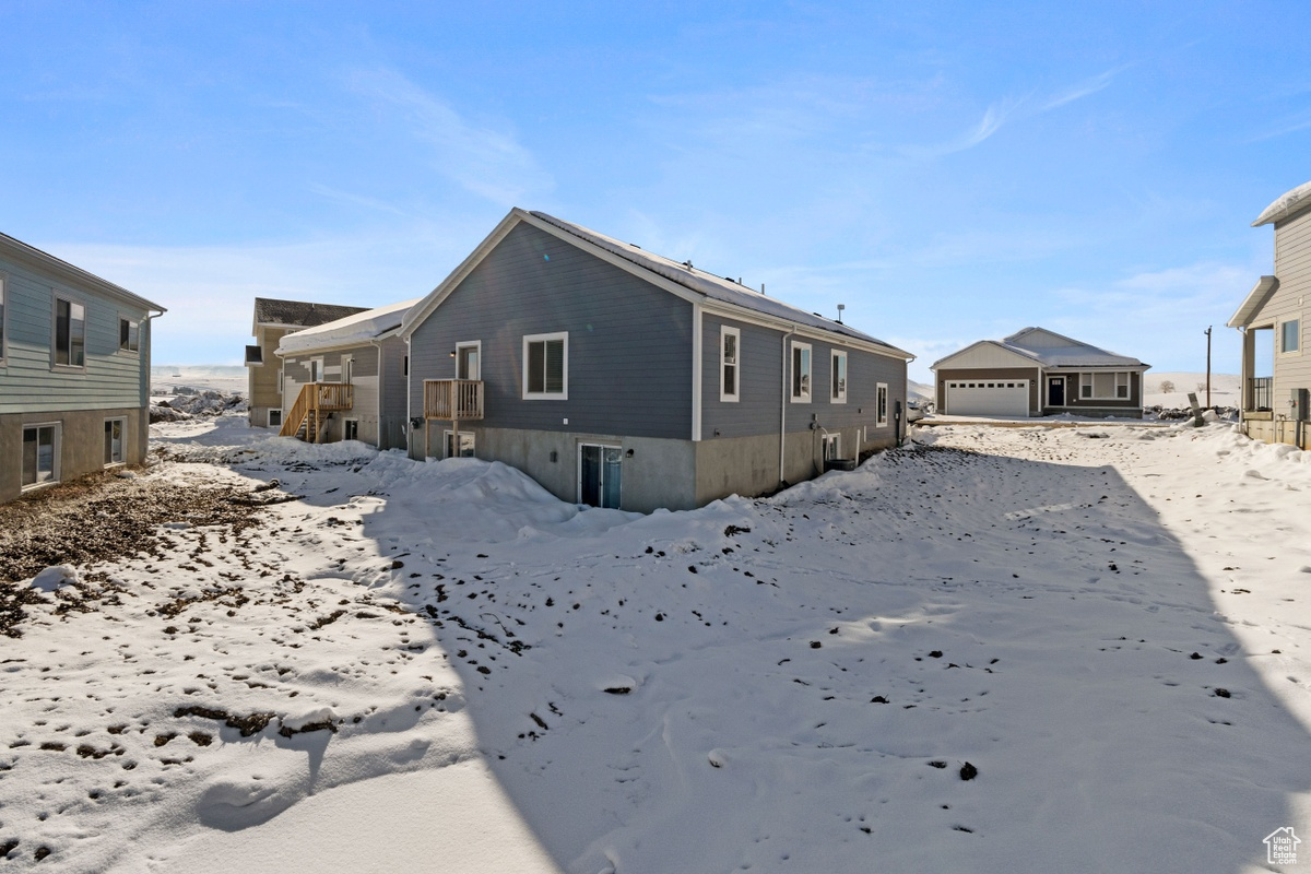 Snow covered house featuring a garage