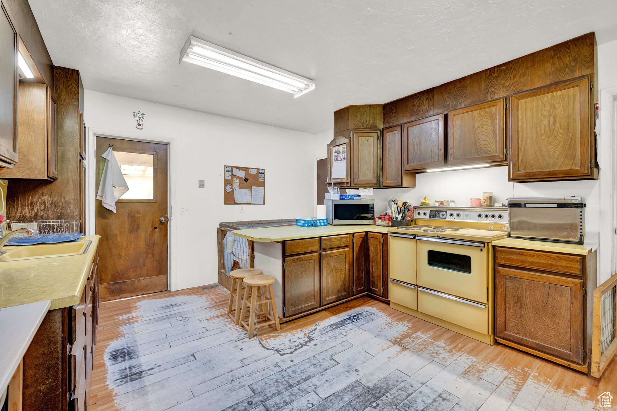 Kitchen featuring sink, range, and wood-style flooring