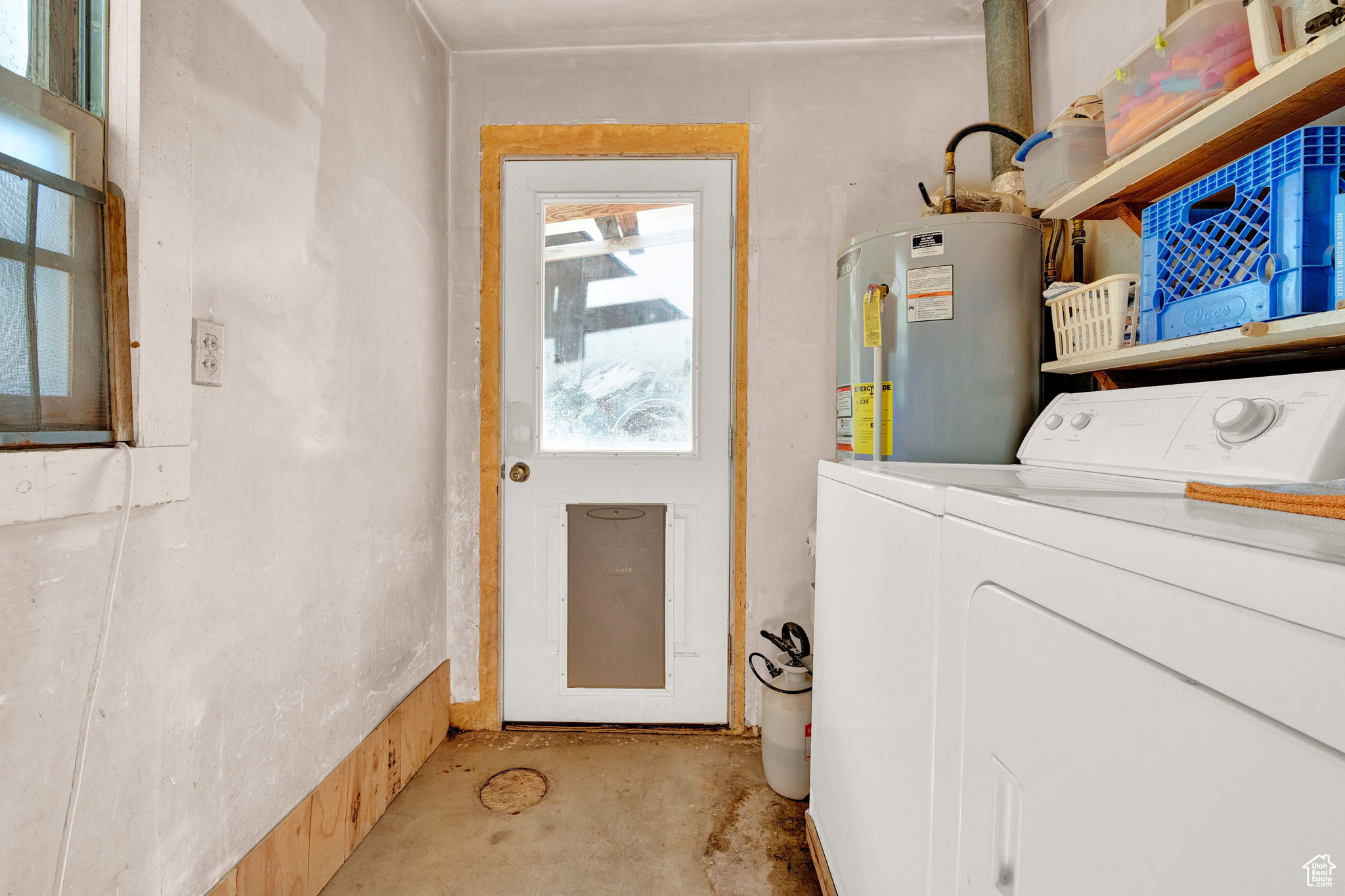 Laundry room featuring water heater and washer and clothes dryer