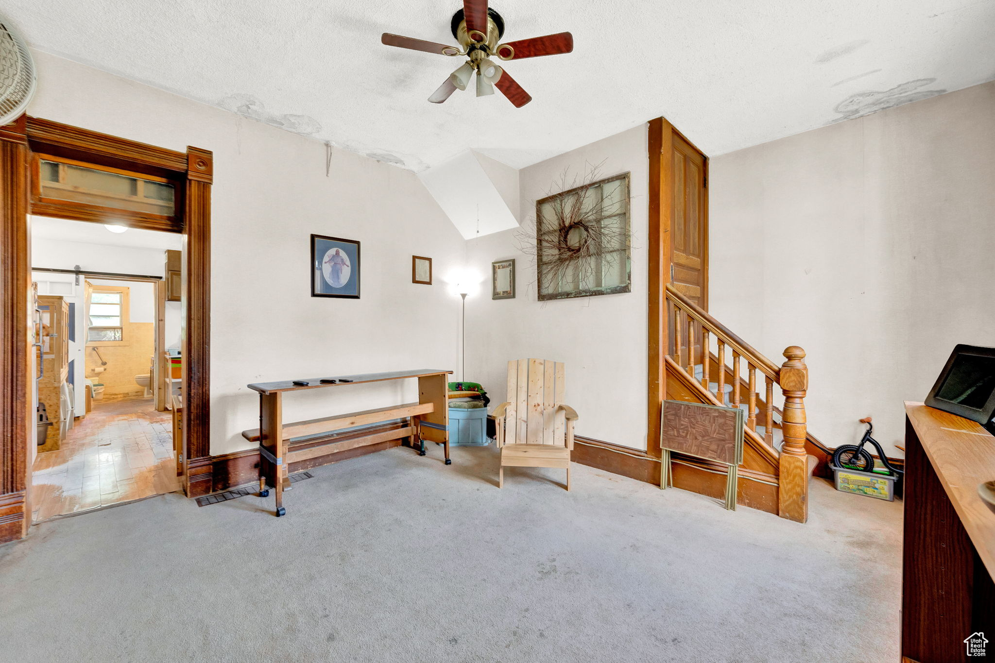 Living room with ceiling fan, vaulted ceiling, and carpet flooring