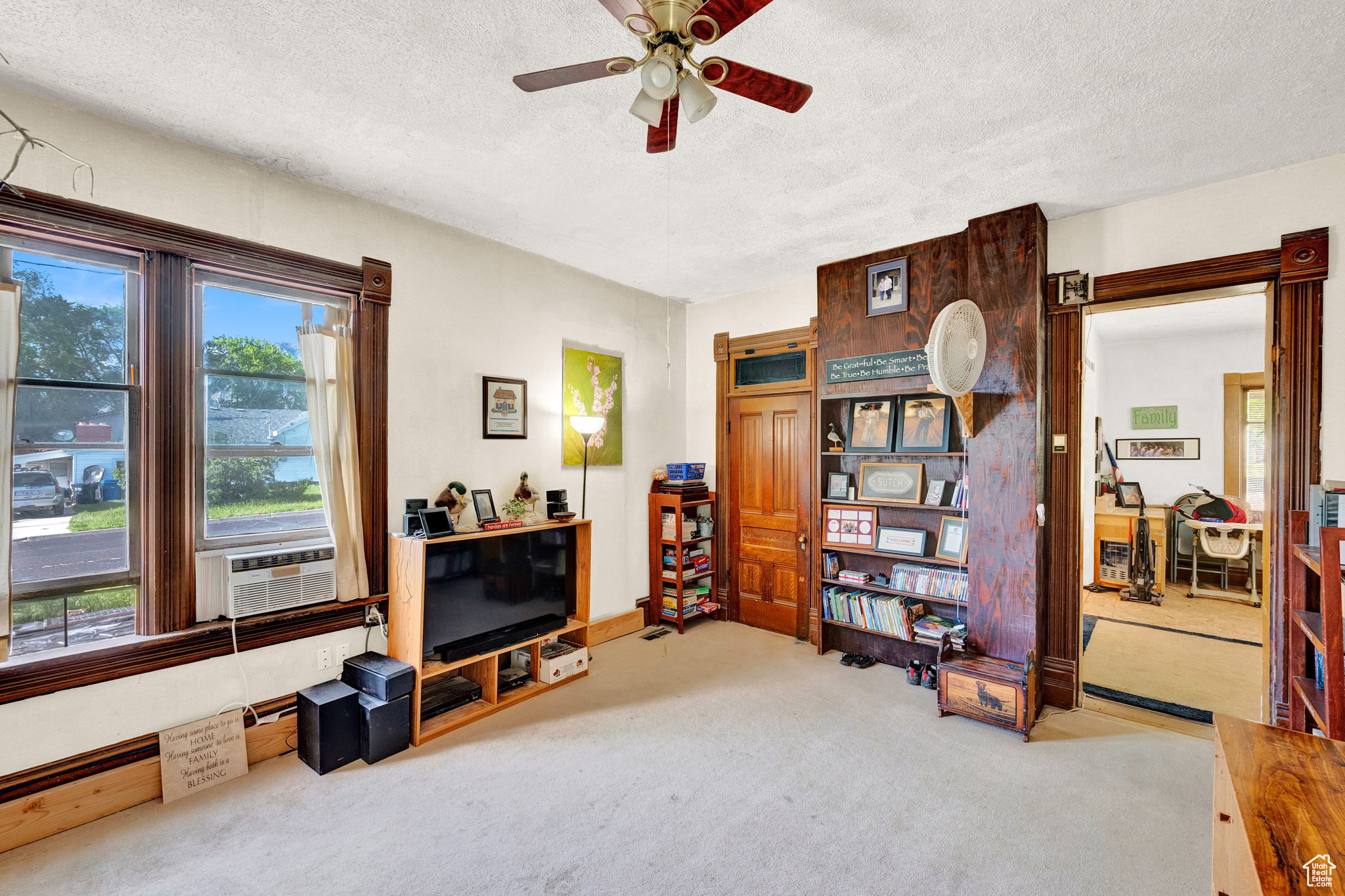 Interior space with ceiling fan, a textured ceiling, and carpet flooring