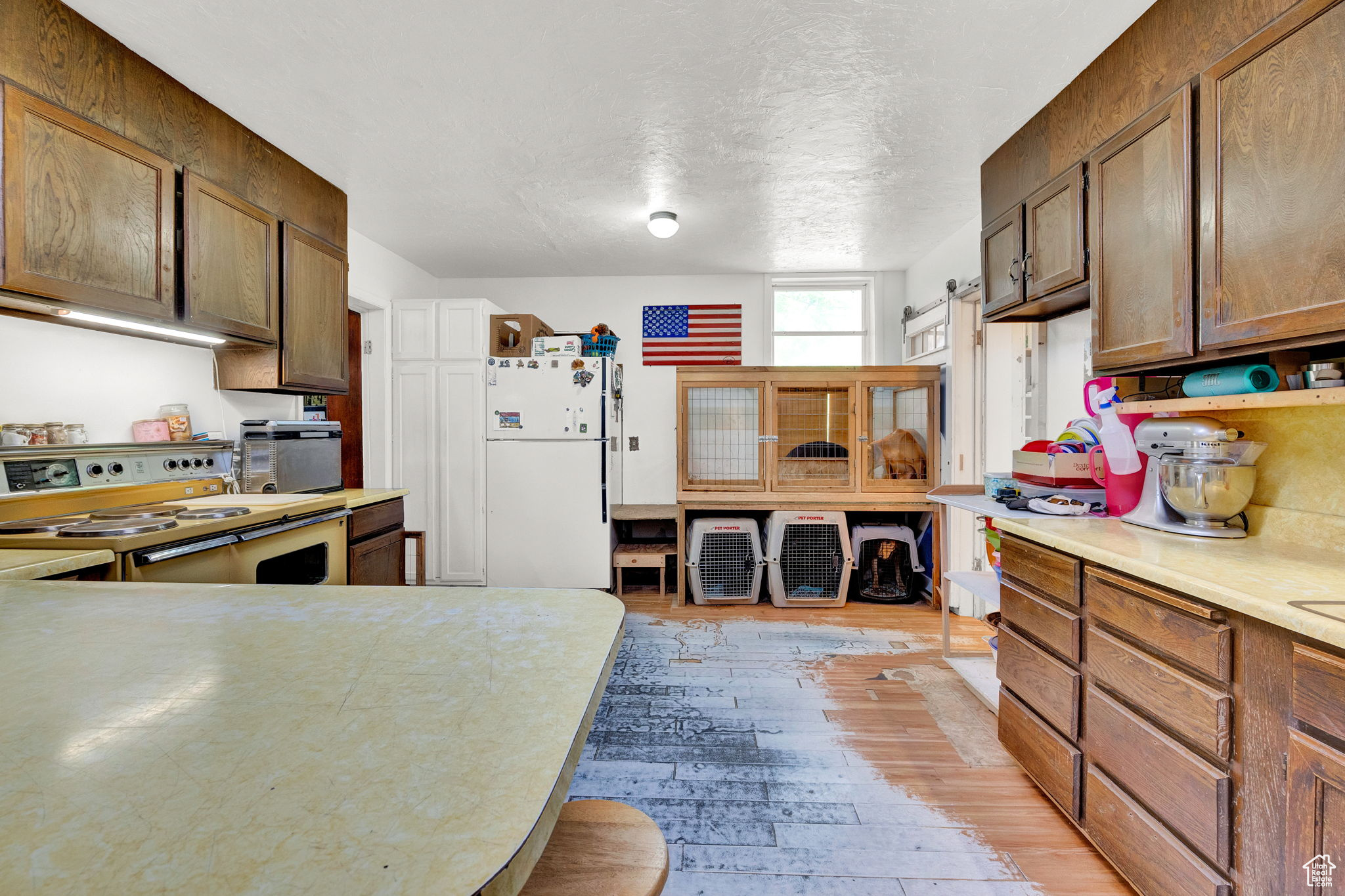 Kitchen with wood-style floors, range, and white refrigerator