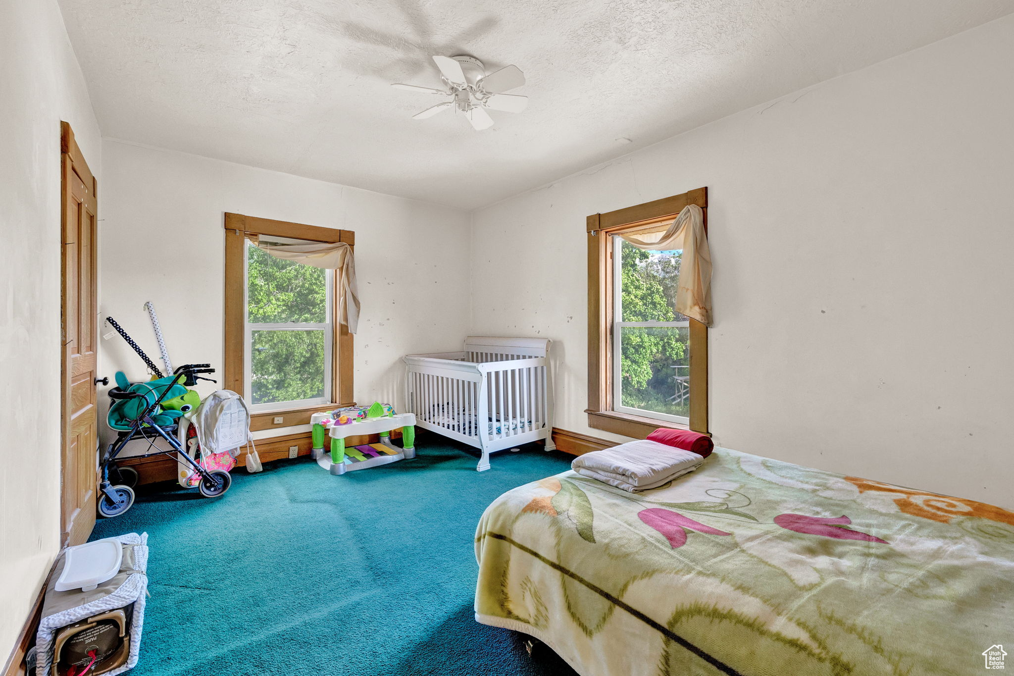 Bedroom with ceiling fan, a textured ceiling, and carpet flooring