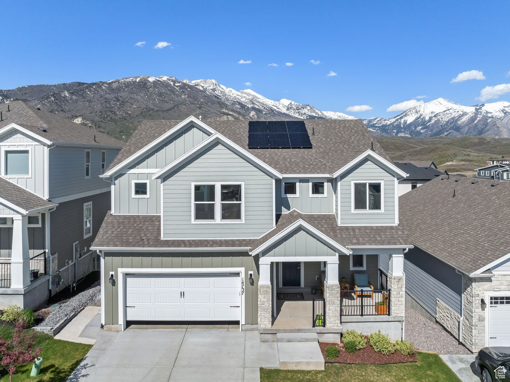 Craftsman-style home with a garage, a mountain view, and solar panels