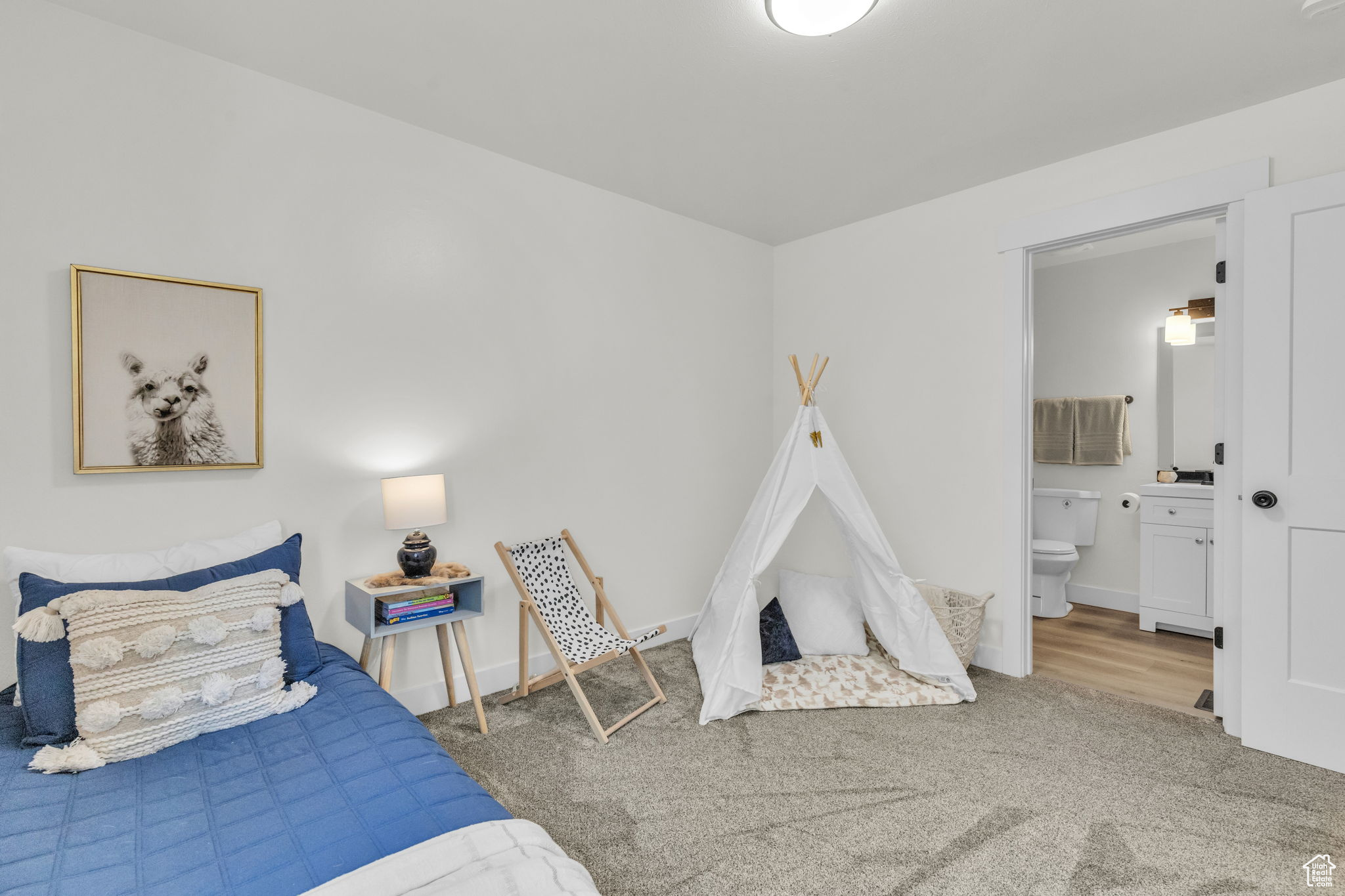 Carpeted bedroom featuring ensuite bath