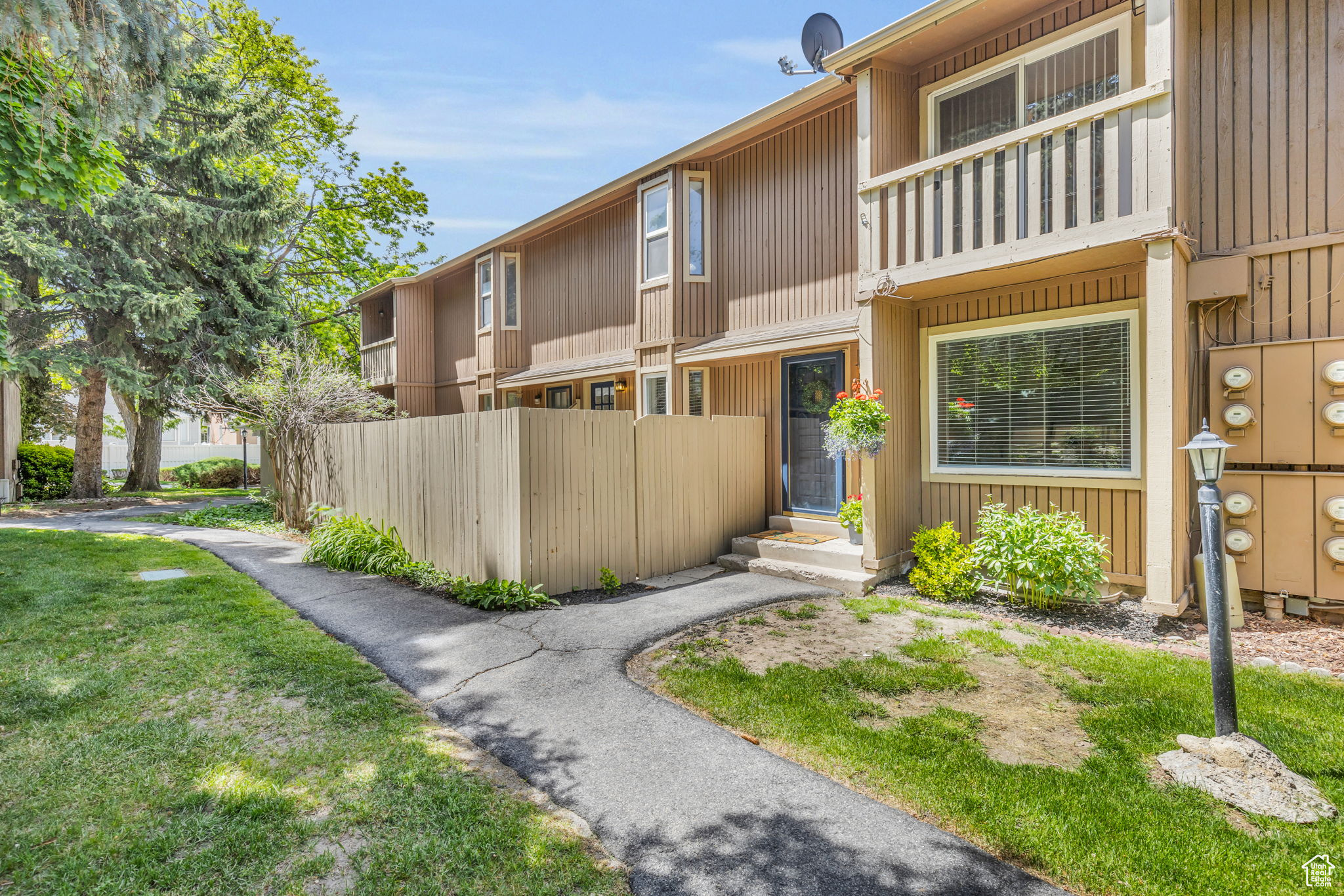 View of front of house with a front lawn and a balcony