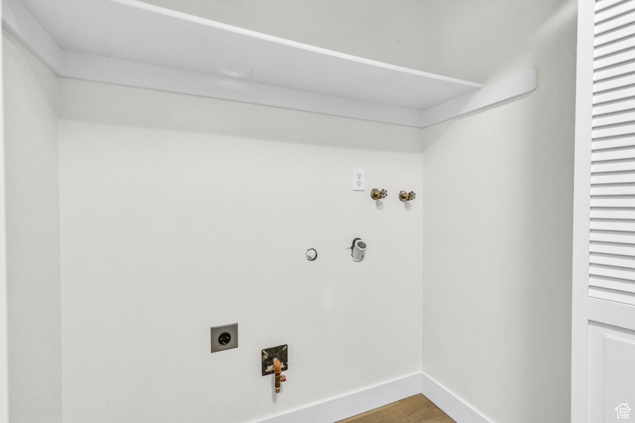 Laundry area with hookup for a gas dryer, wood-type flooring, washer hookup, and hookup for an electric dryer