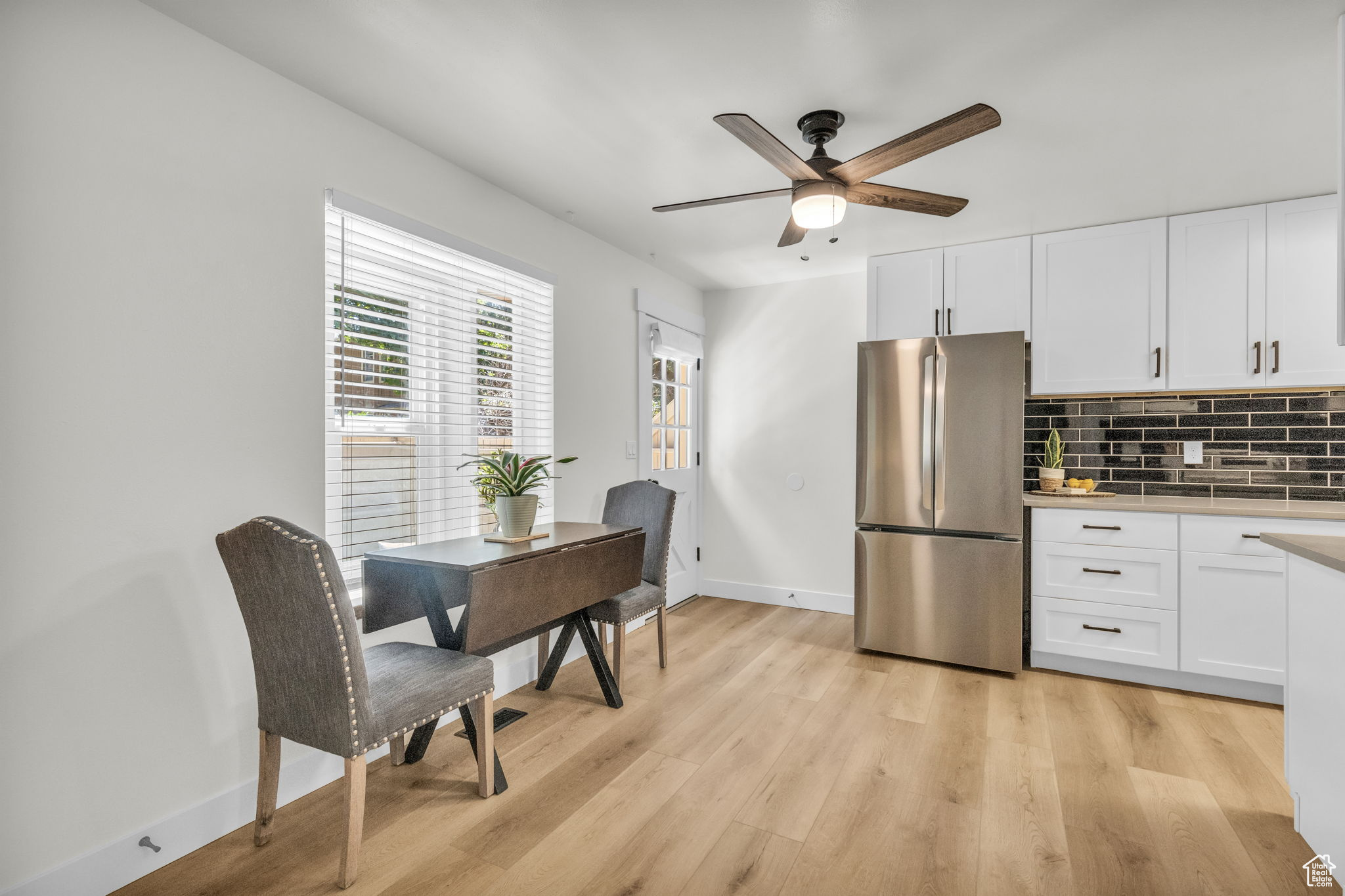 Kitchen featuring light hardwood / wood-style floors, stainless steel fridge, and white cabinets