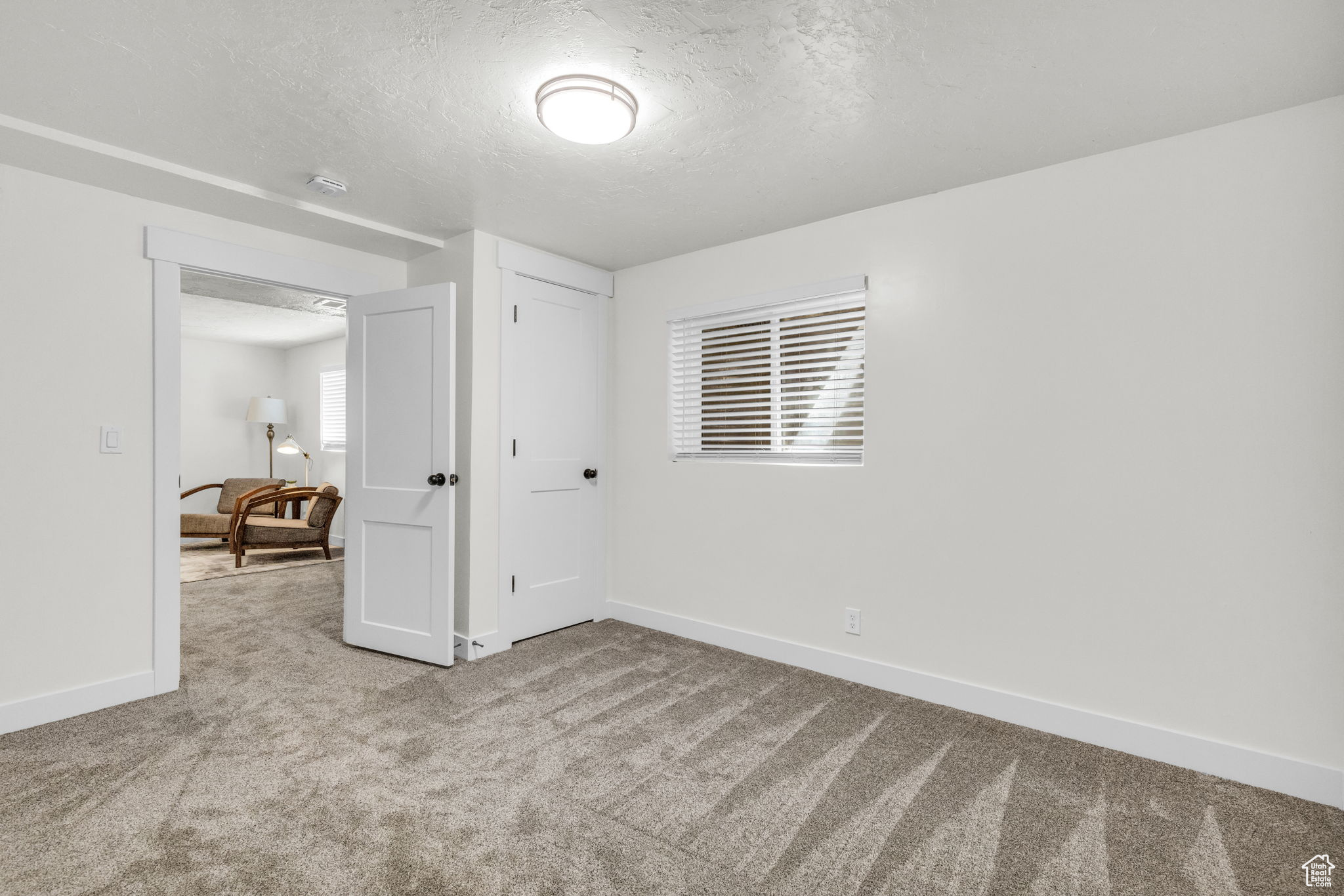 Carpeted empty room with a textured ceiling