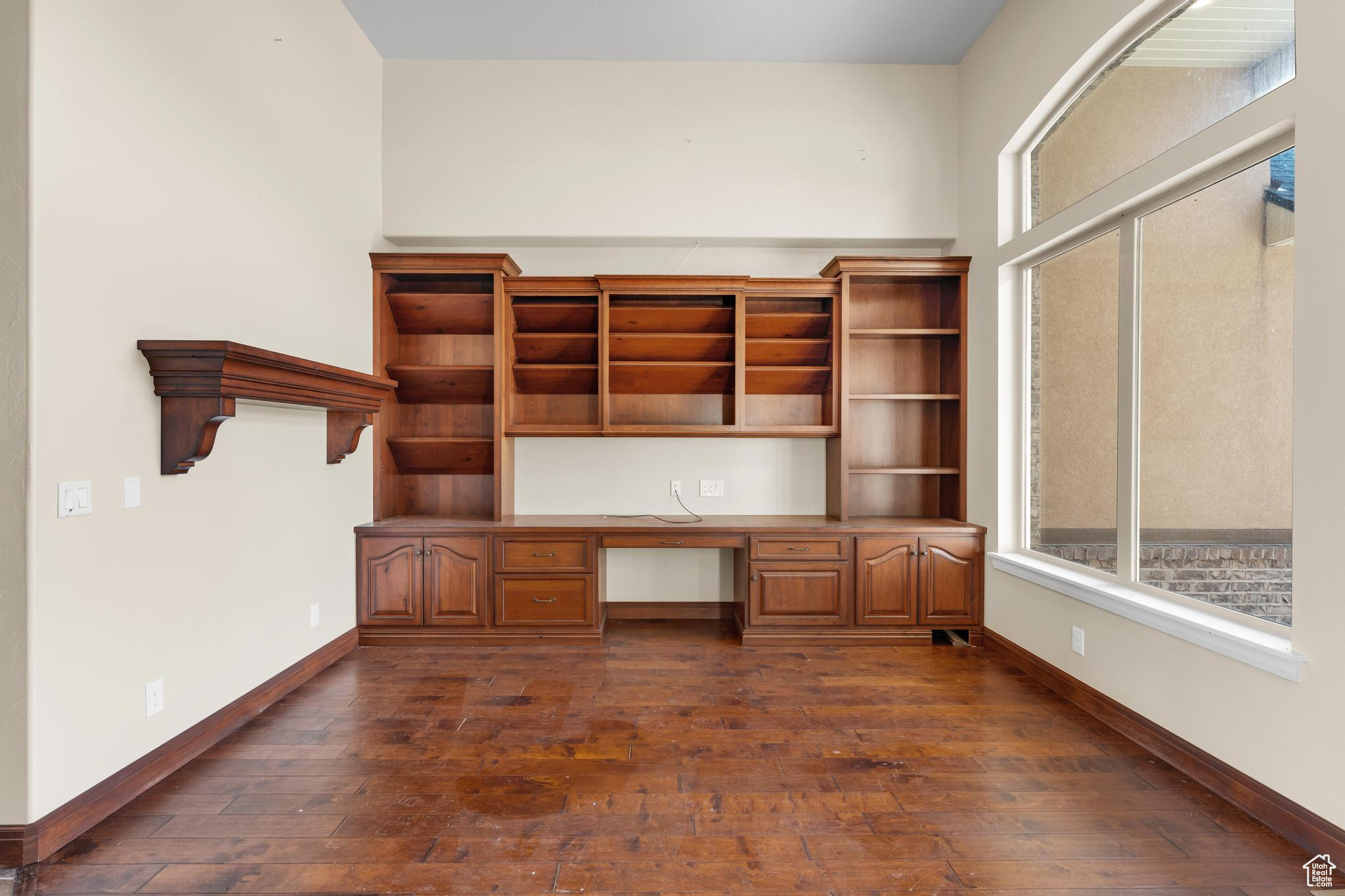 Office with dark wood-type flooring and built in desk