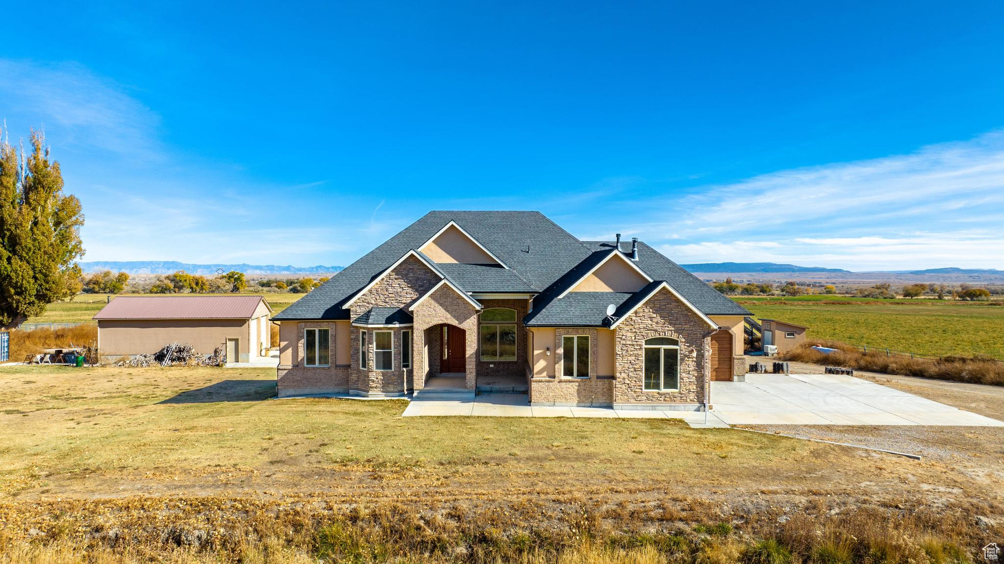 Rambler inspired home featuring a front yard, a patio area, and a mountain view