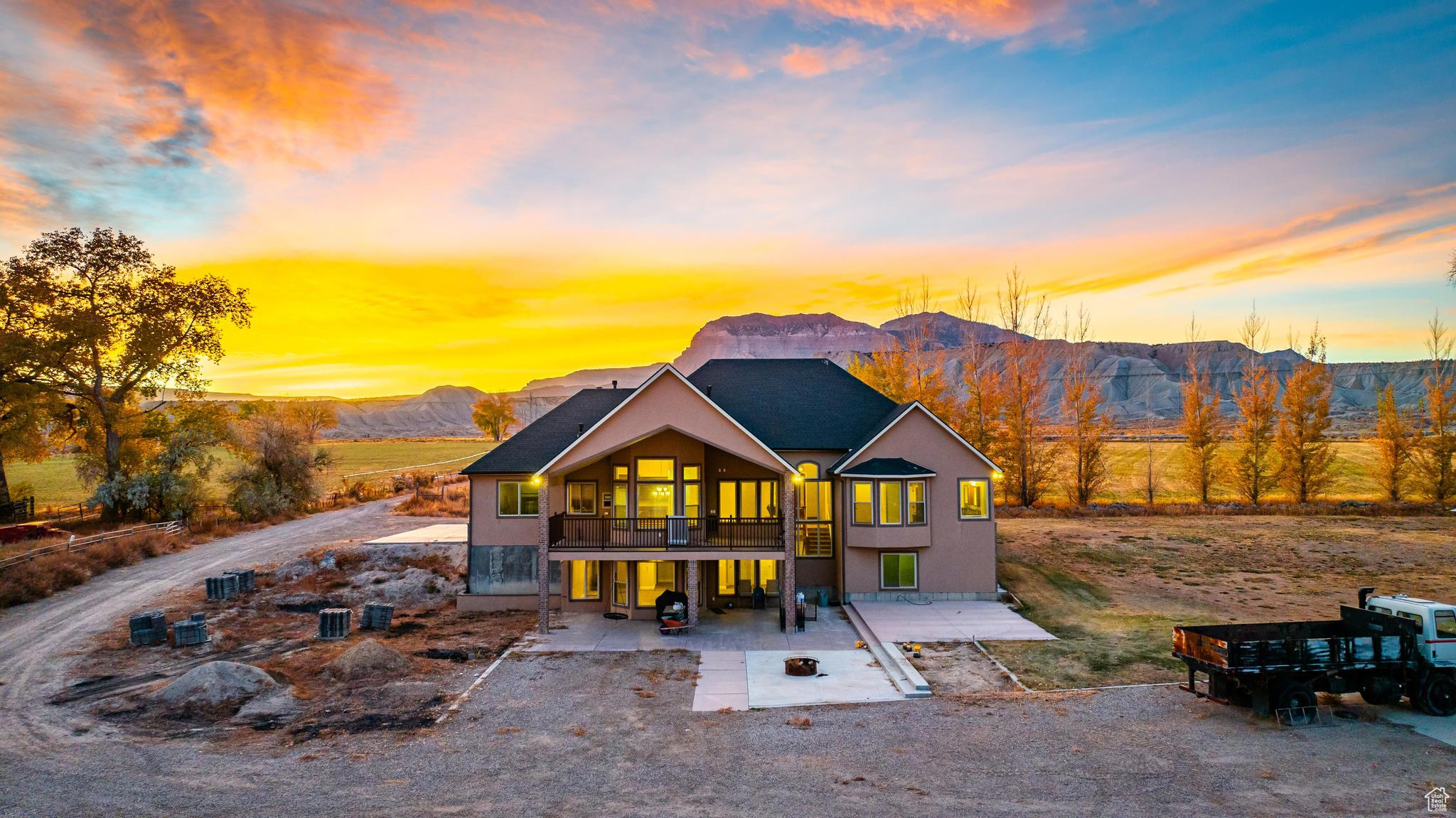 View of back of home with a patio, a balcony, and a mountain view