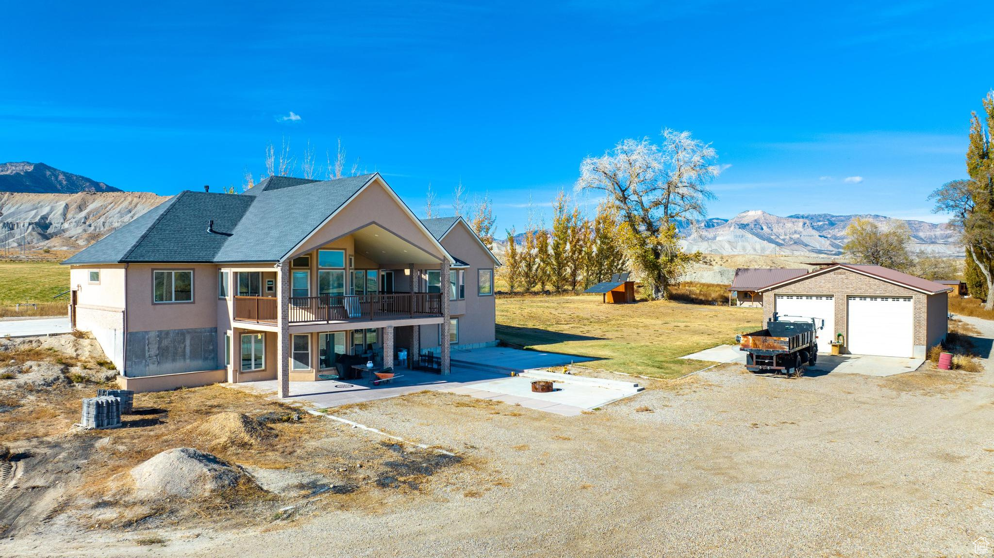 View of yard with a balcony, a large detached working garage, and a mountain view