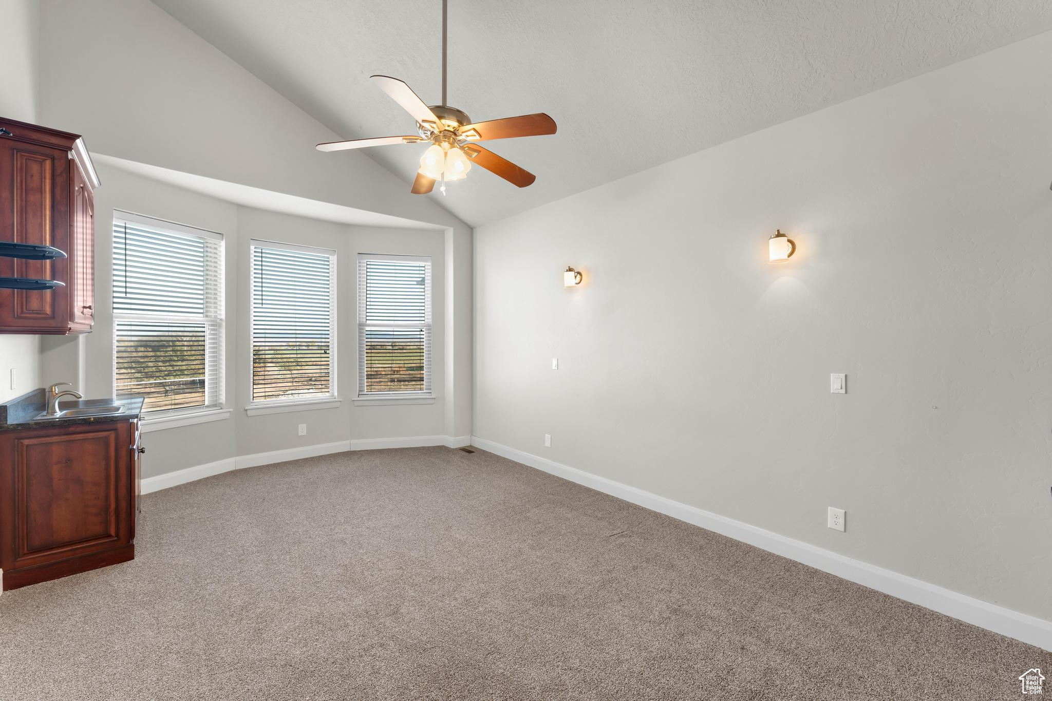 Master bedroom featuring ceiling fan, sink, and high vaulted ceiling