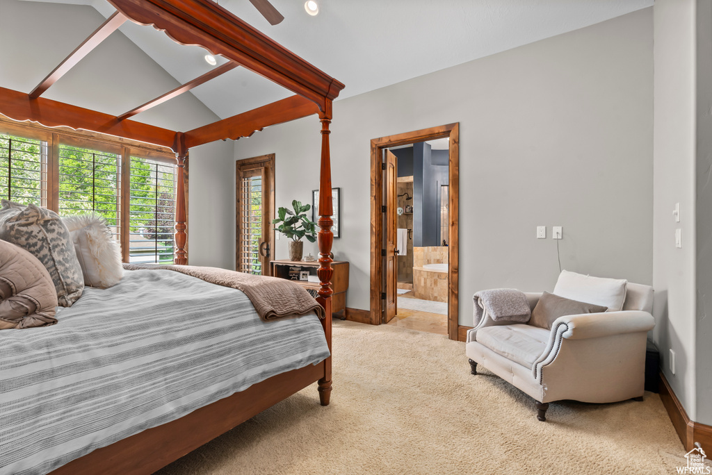 Carpeted bedroom with vaulted ceiling with beams and connected bathroom