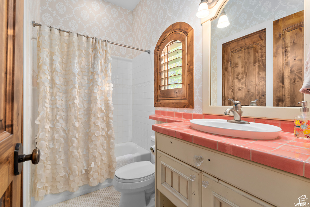 Full bathroom with shower / bathtub combination with curtain, tile flooring, toilet, and large vanity