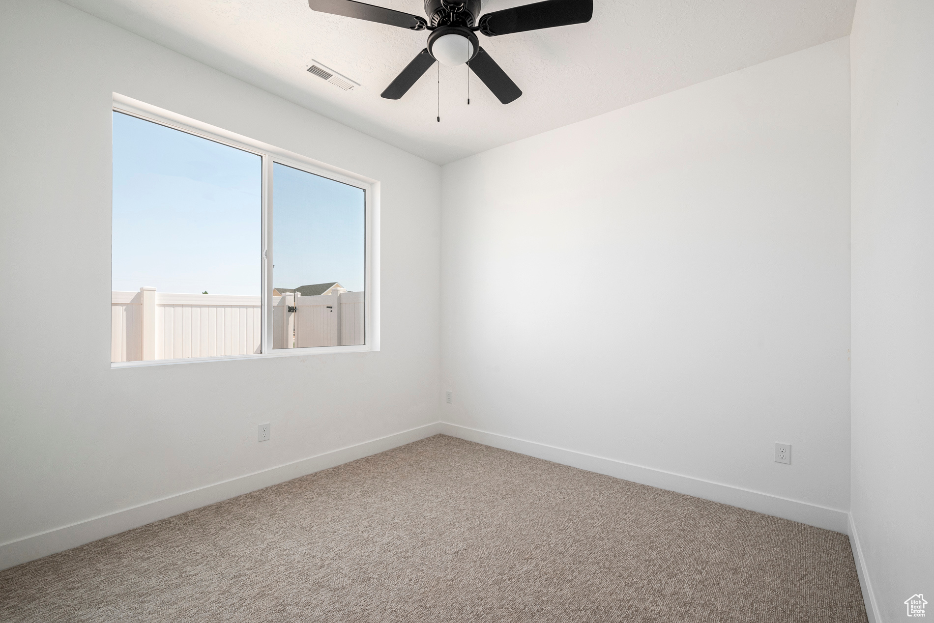 Carpeted empty room with ceiling fan