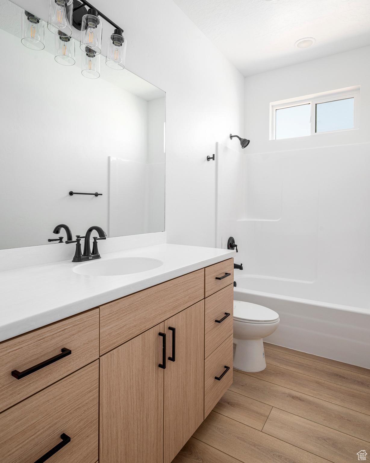 Full bathroom featuring toilet, shower / bath combination, hardwood / wood-style floors, and vanity