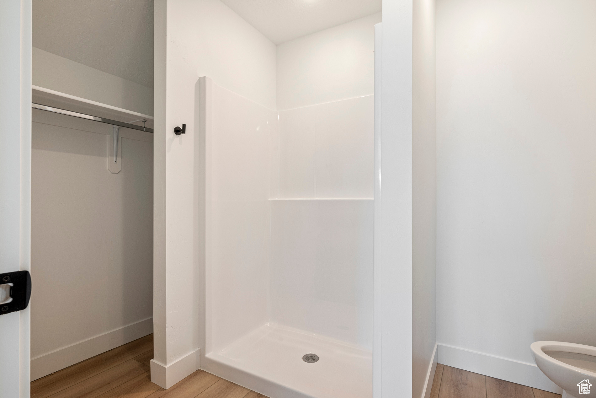 Bathroom with toilet, hardwood / wood-style flooring, and walk in shower