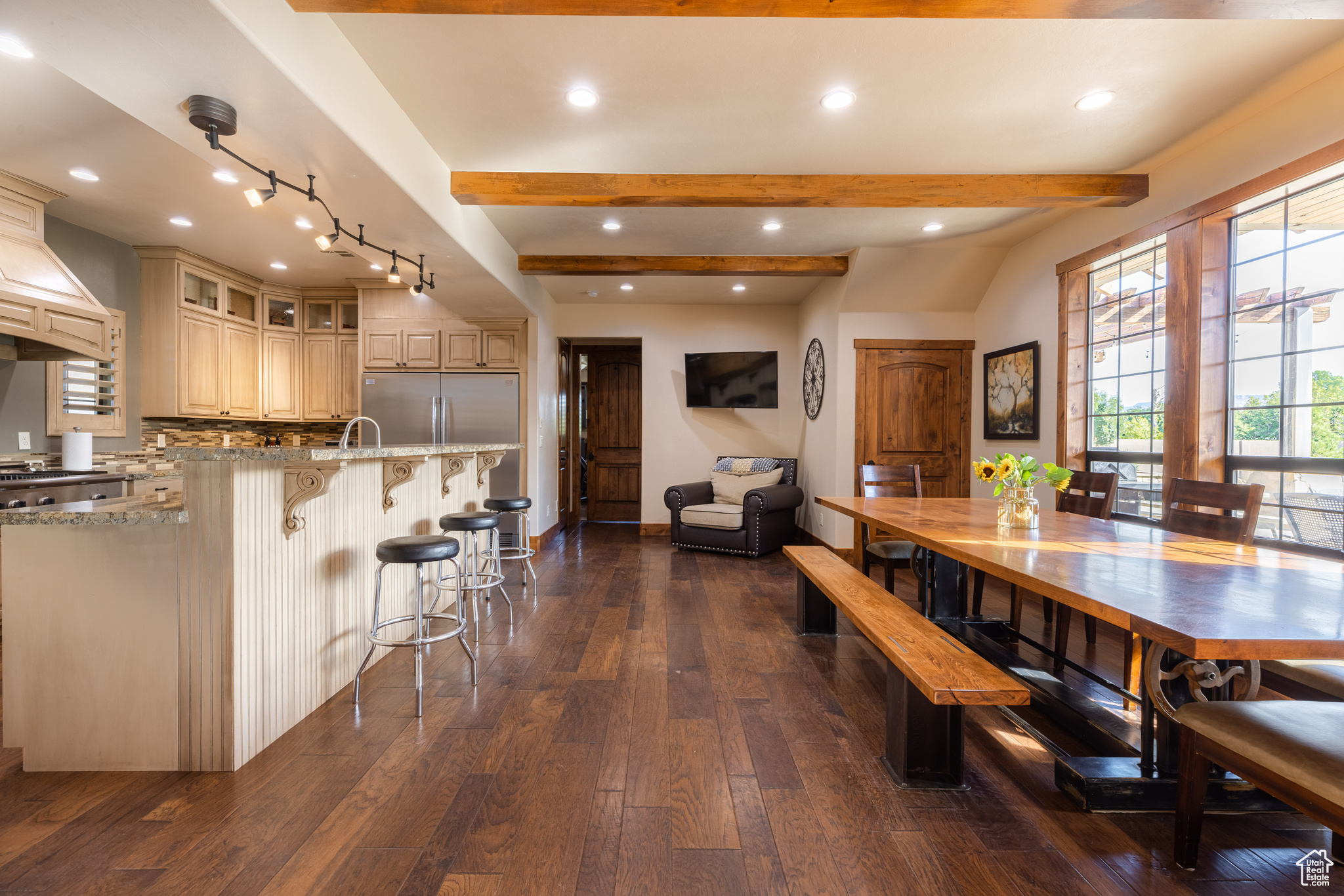 Dining room featuring beamed ceiling, hardwood / wood-style floors, track lighting, and sink